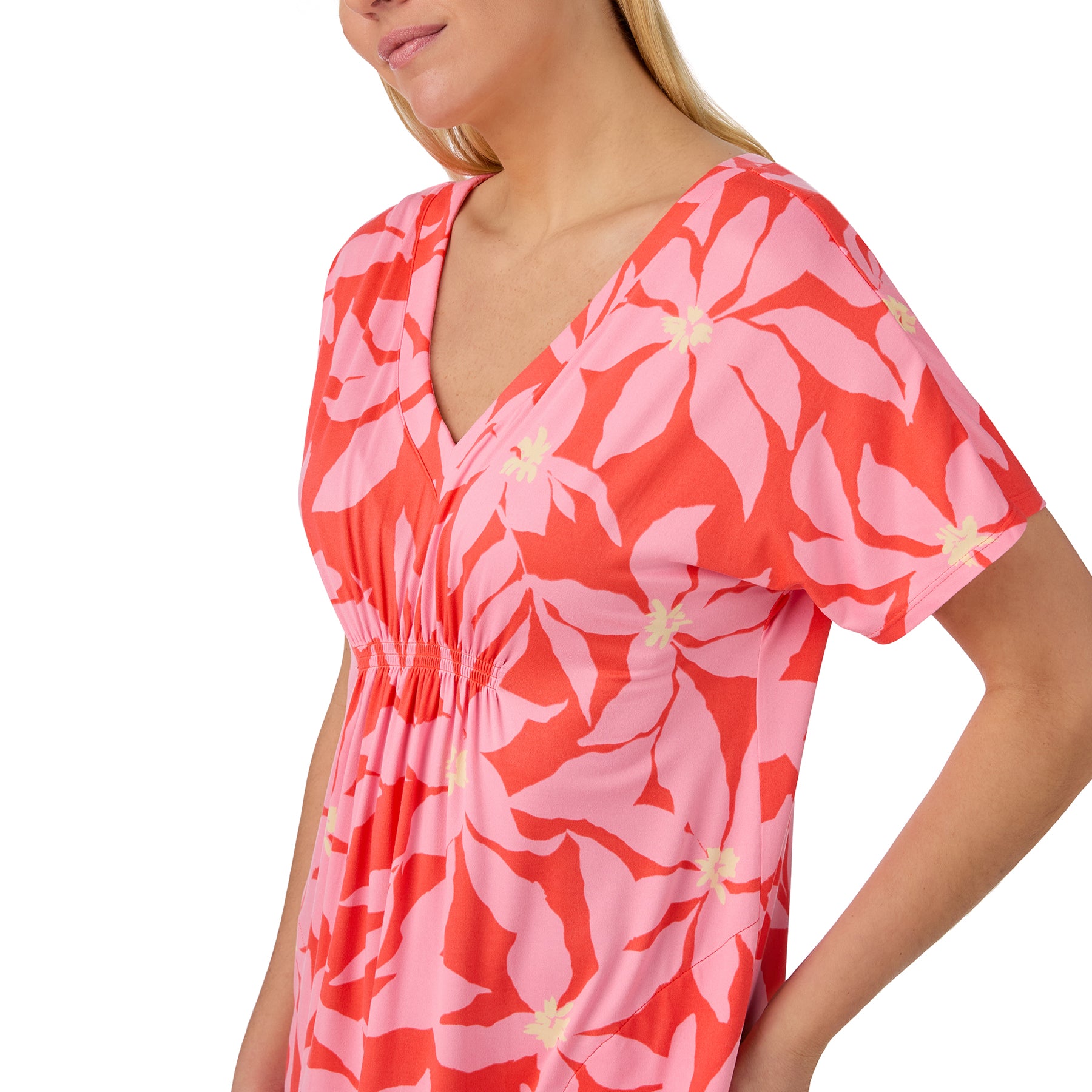 Woman wearing a coral and pink floral print nightgown with short sleeves and soft V-neckline