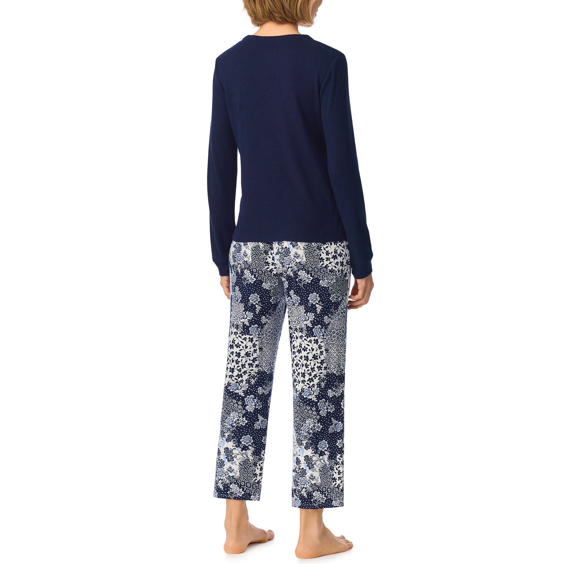 Back view of navy long-sleeve pajama top and cropped blue and white floral patchwork pajama pants.