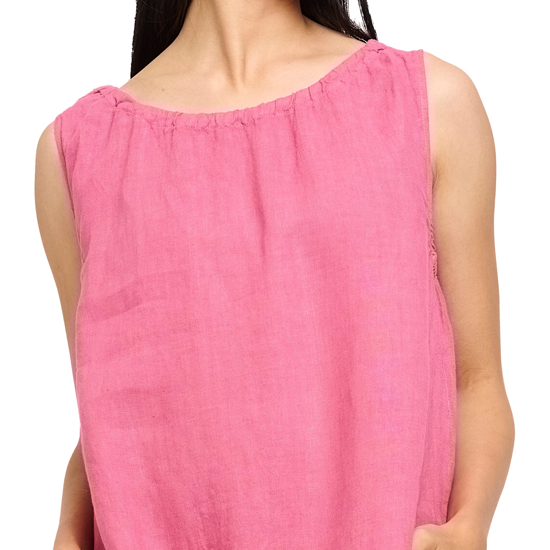 Sleeveless linen dress in pink strawberry with gathered neck and pockets. Front view close up on model.