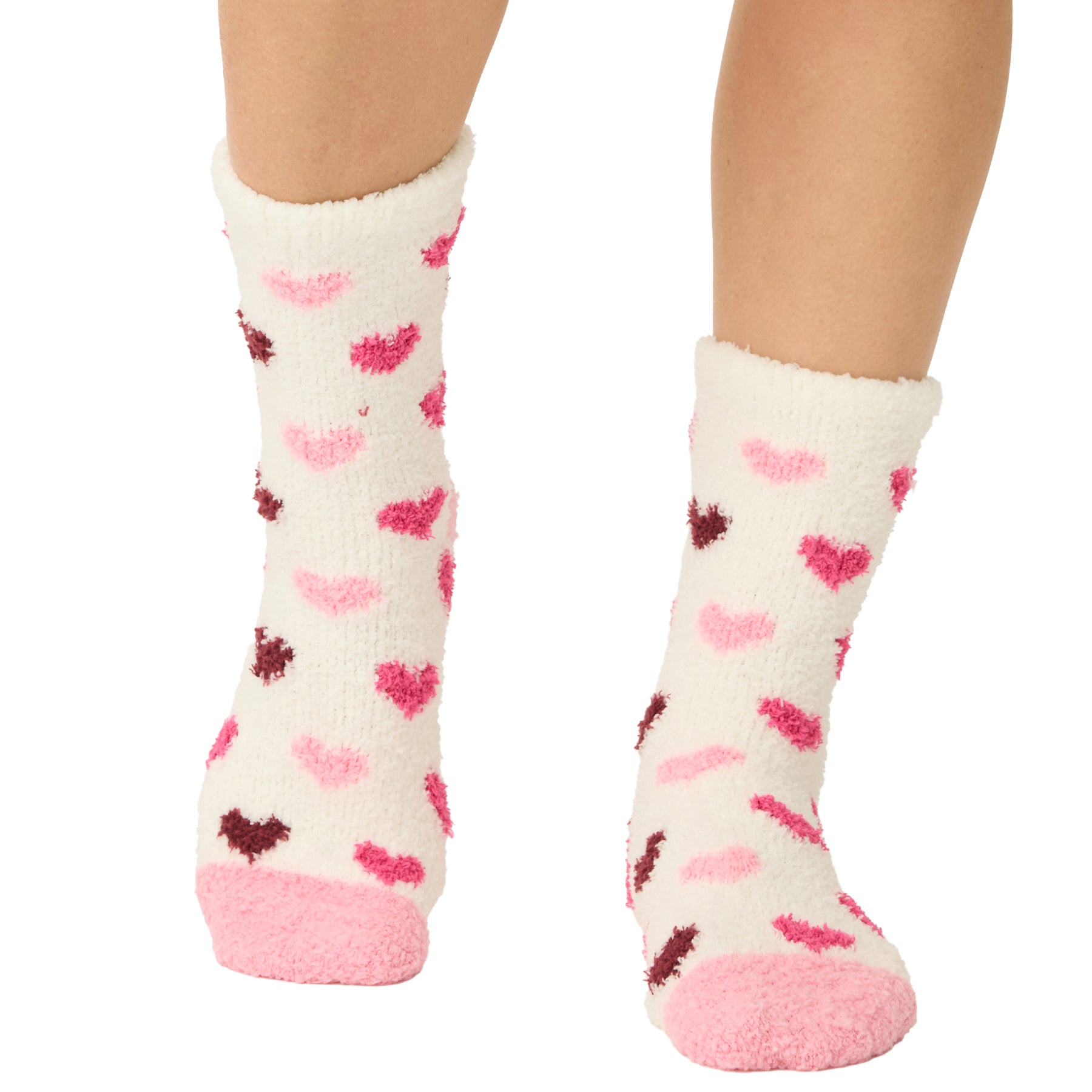 White socks with pink and red heart patterns worn by a person on a white background