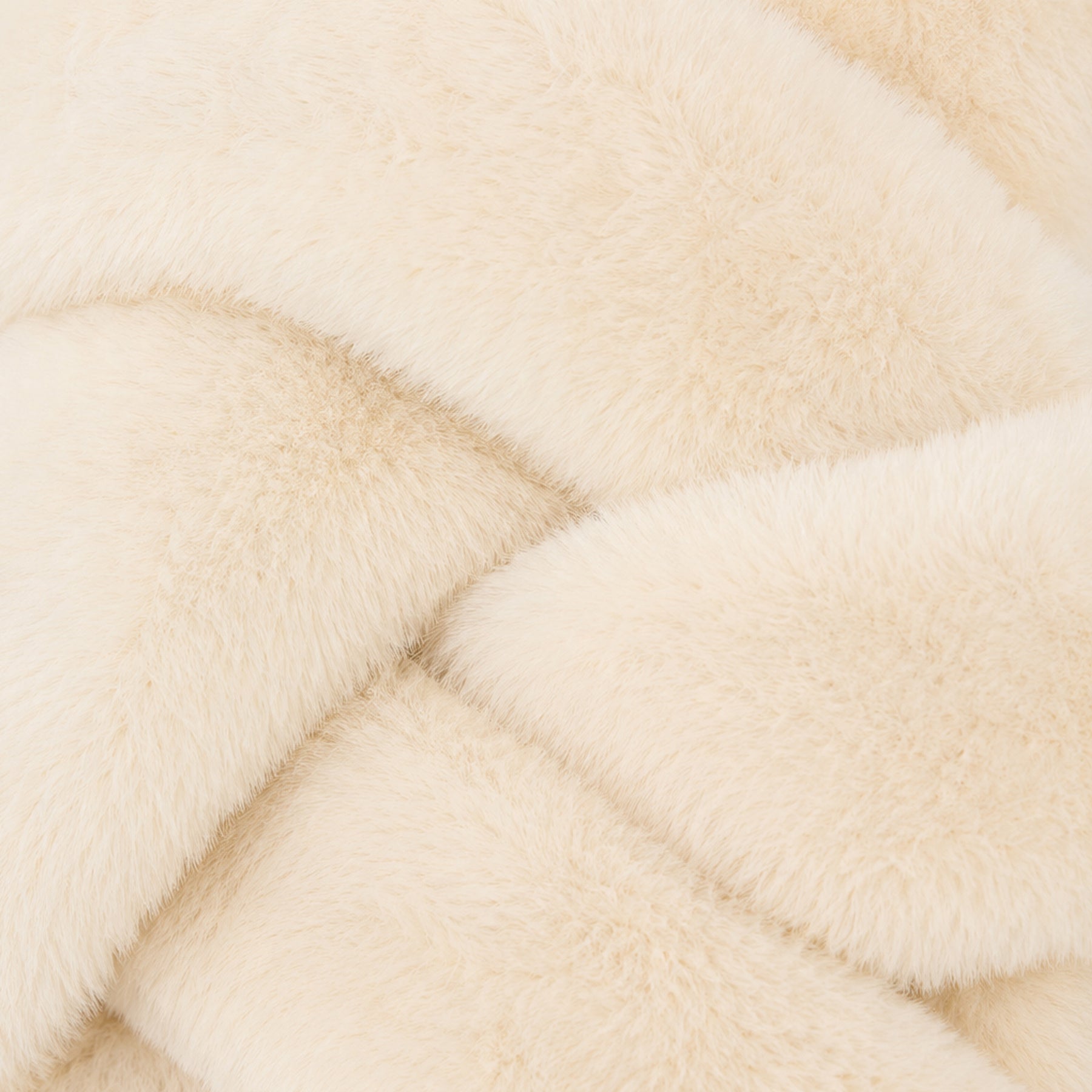 Close-up of soft ivory faux fur fabric showing its plush, fluffy texture.