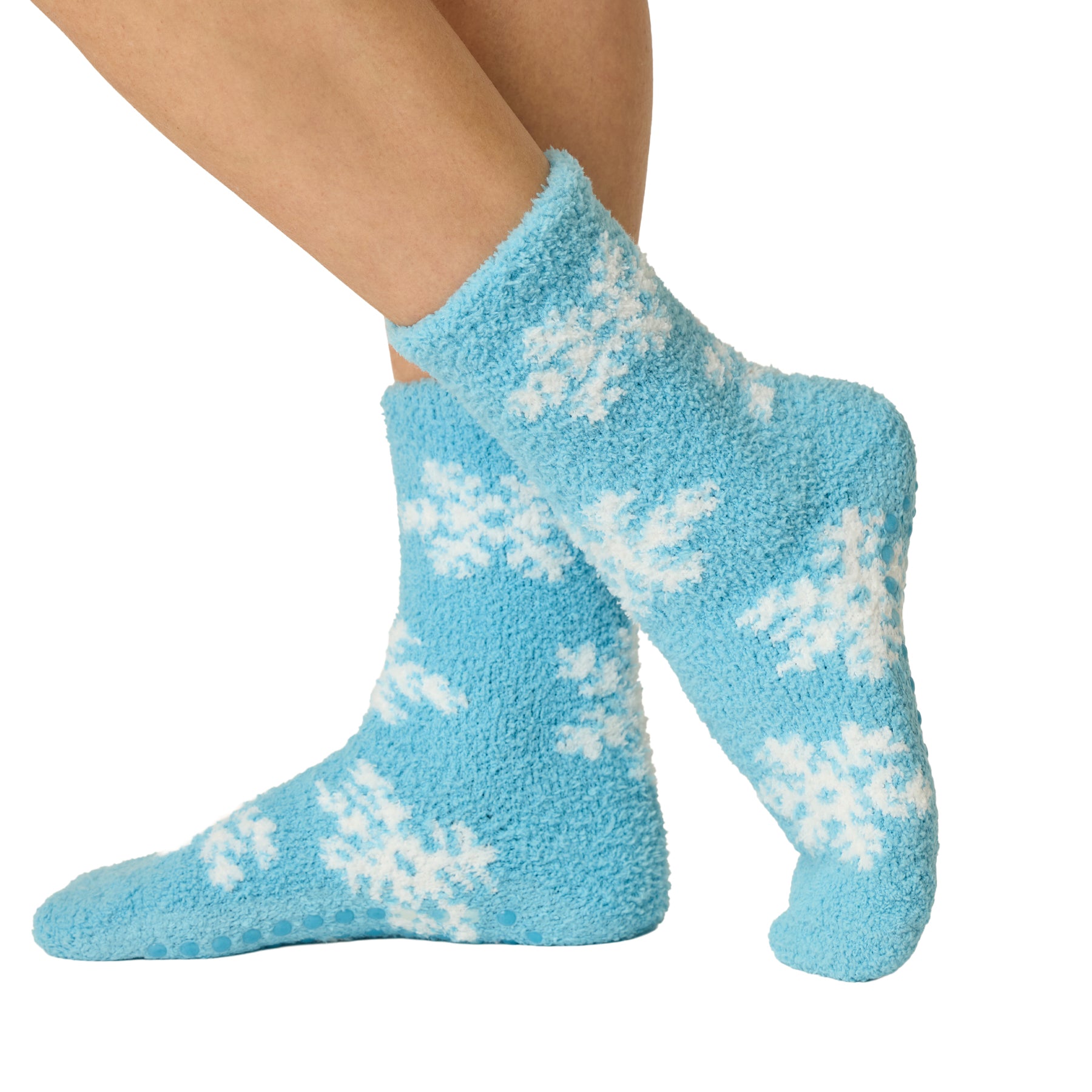 Side view of blue plush socks featuring white snowflakes and non-slip grips on the soles.