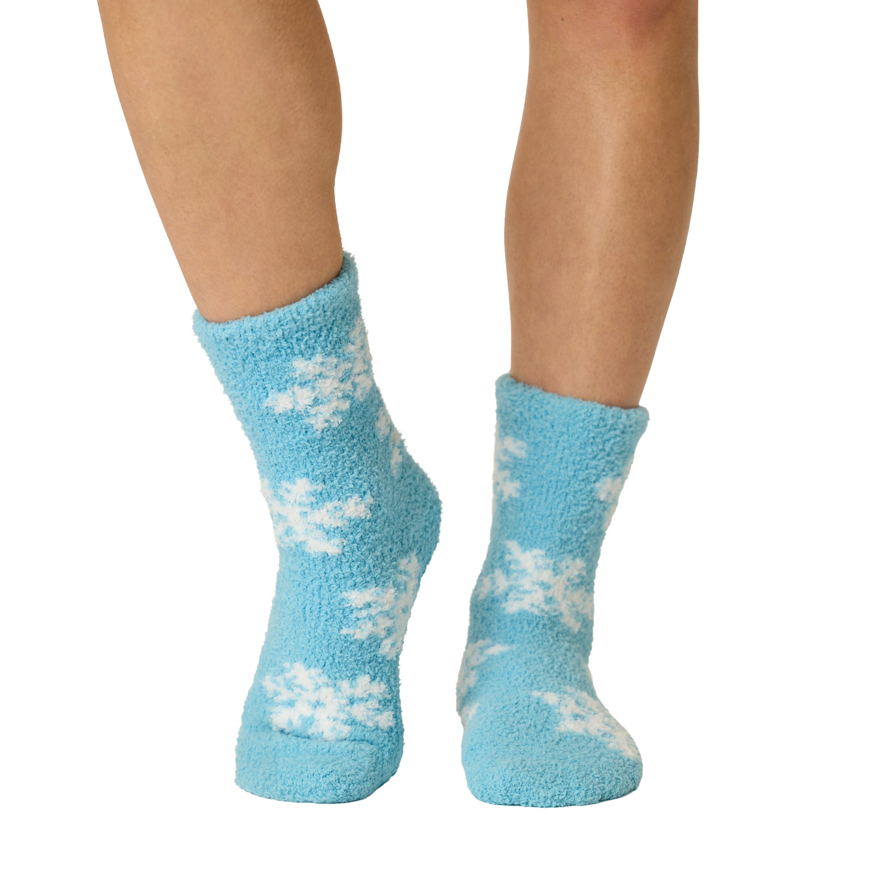 Front view of blue fuzzy crew socks with an all-over white snowflake design.