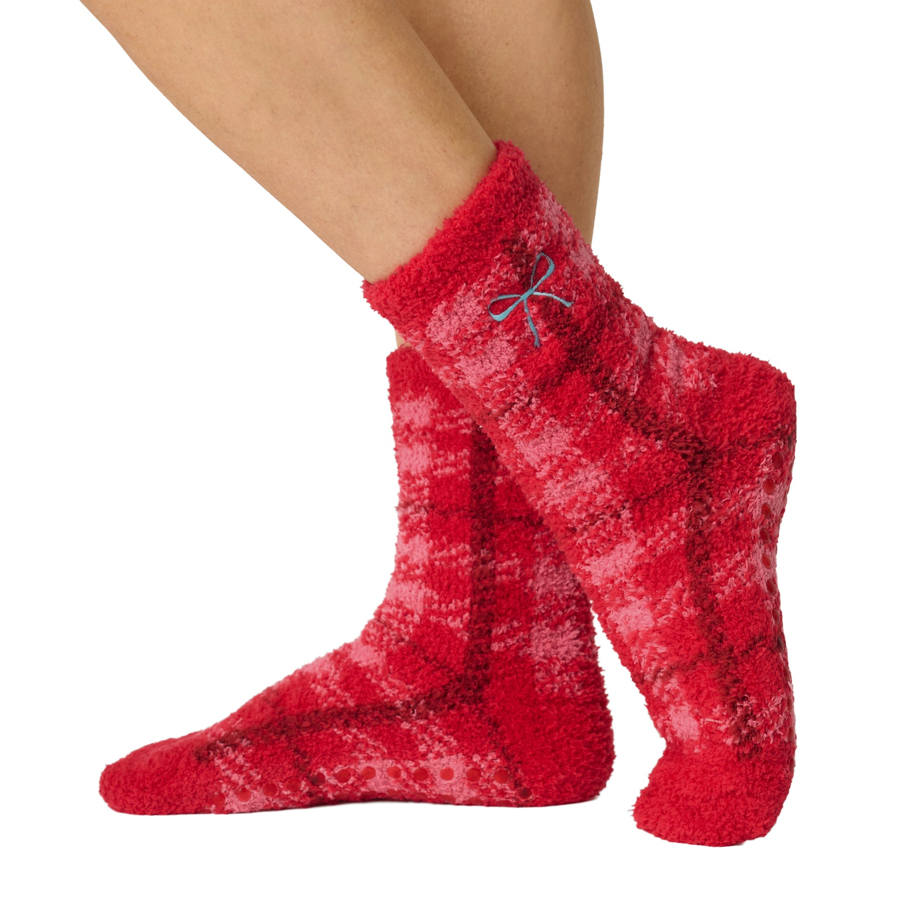 Side view of red and pink plaid plush crew socks featuring a blue embroidered bow and cozy fuzzy texture.