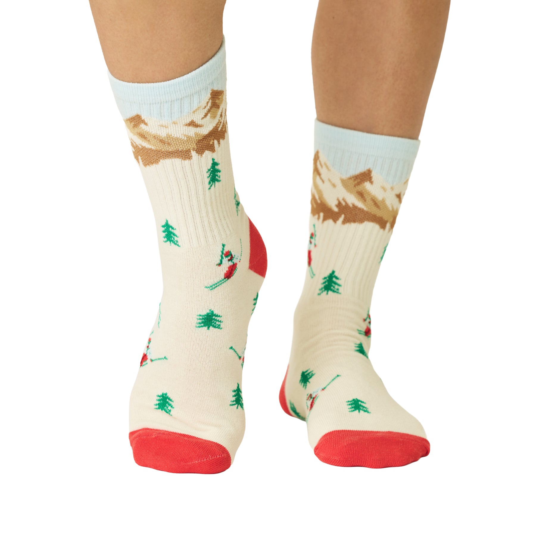 Front view of ivory crew socks with colourful skier, pine tree and mountain print, finished with red toes and heels.