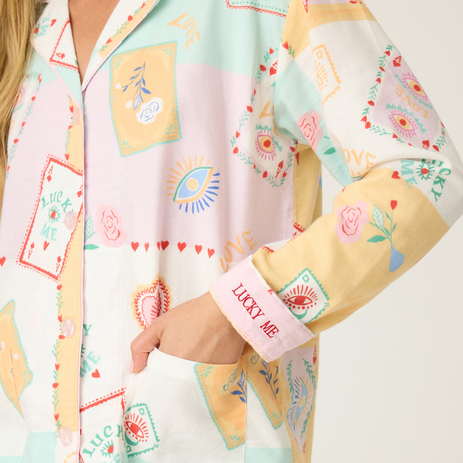 Close-up of PJ Salvage RUFLPJ flannel pajama top in natural lucky print showing “Lucky Me” embroidery on cuff