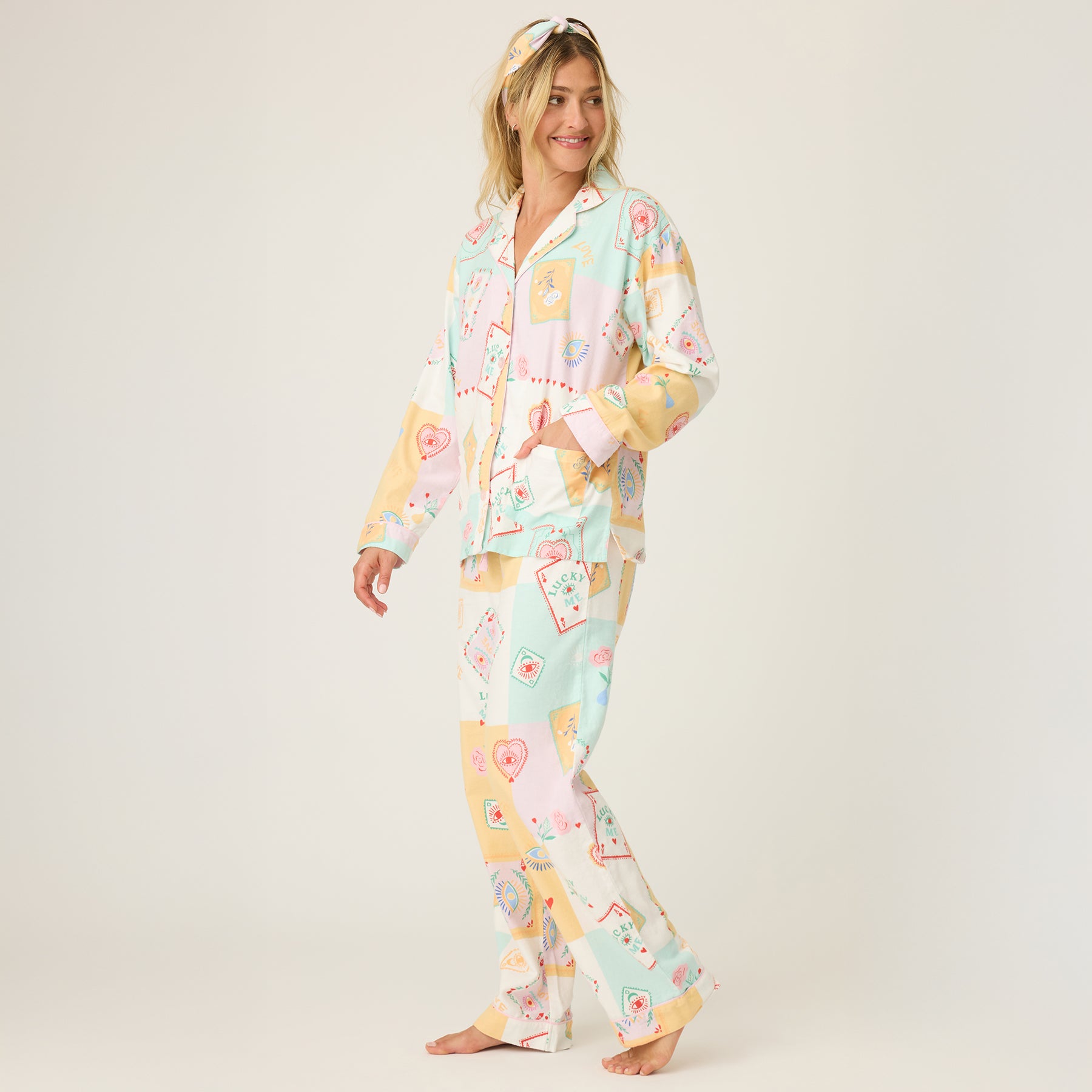 Model wearing PJ Salvage RUFLPJ flannel pajama set in natural lucky print – side view with pastel card motifs