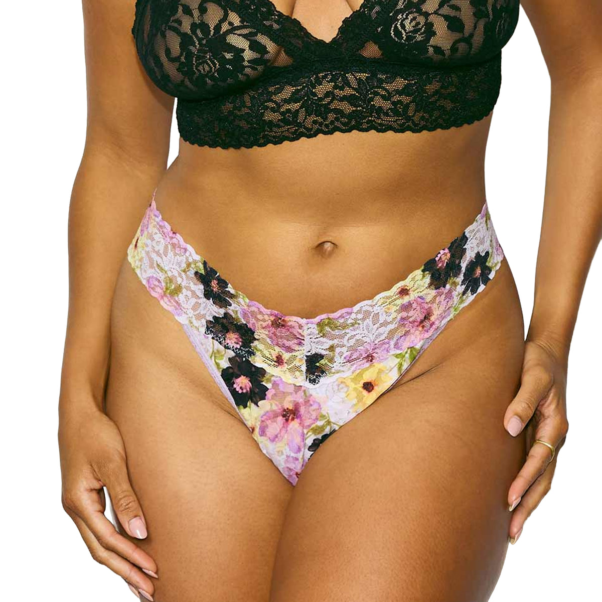 Close-up of a floral lace high-leg thong featuring a multicolour floral print and scalloped lace waistband, styled with a black lace bralette.