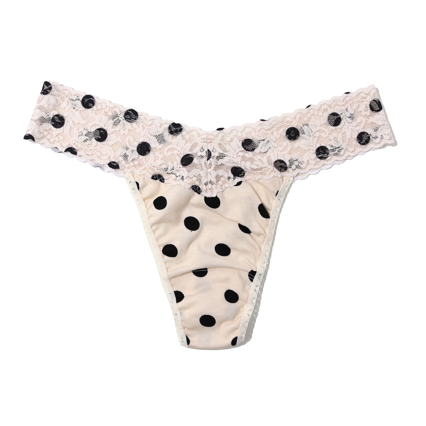 Flat lay of cream thong with black polka dots and lace waistband, lightweight and soft stretch fabric
