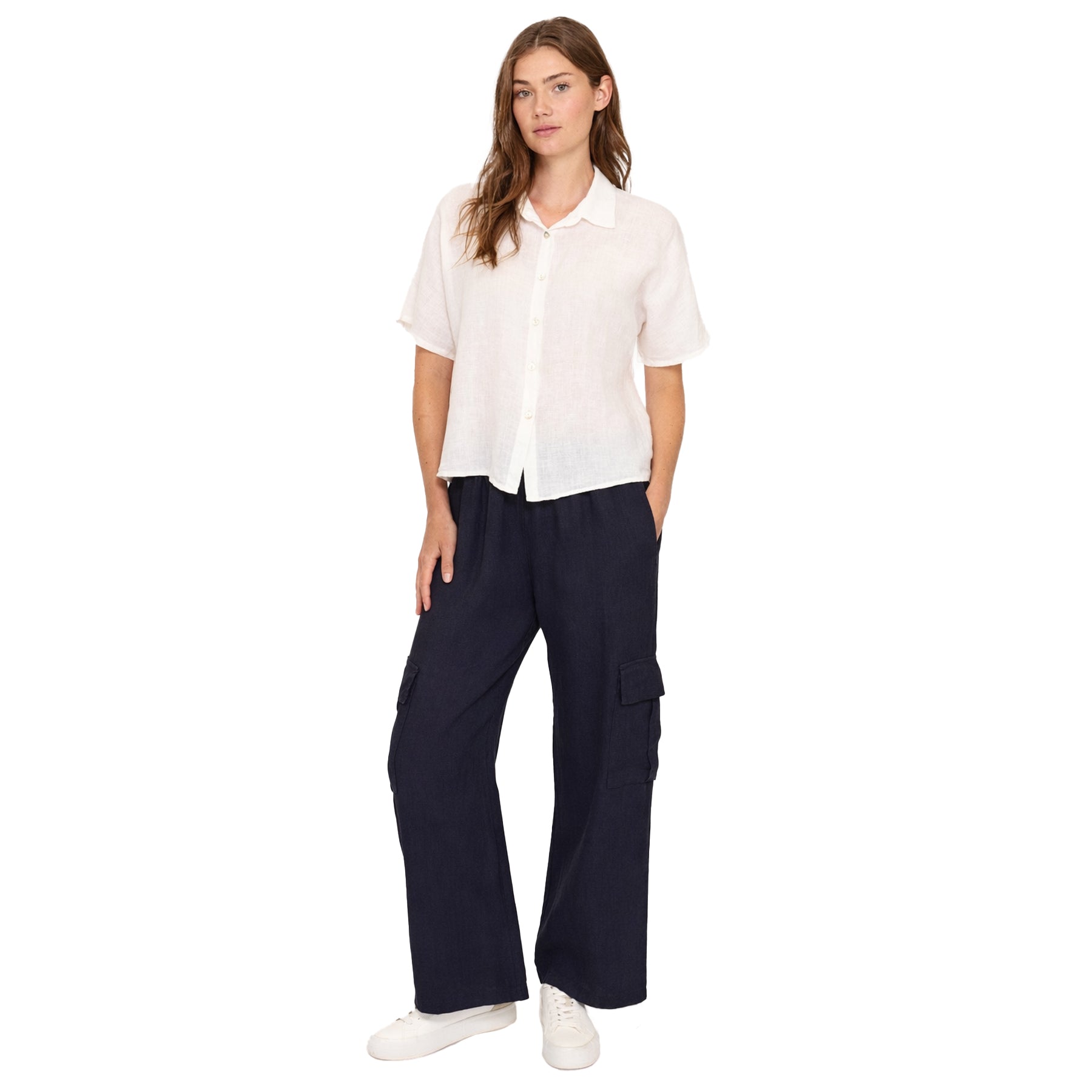 Woman wearing a white shirt and navy cargo pants on a white background