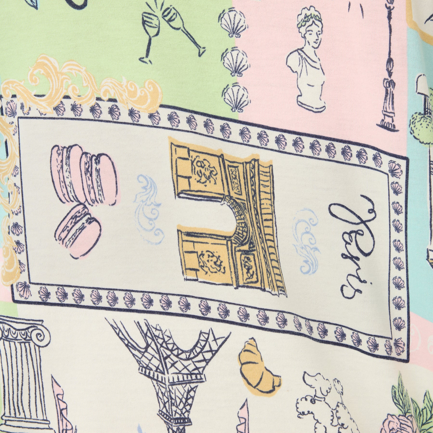 Fabric close-up of the pastel travel print featuring illustrated Paris landmarks, macarons, and decorative borders.
