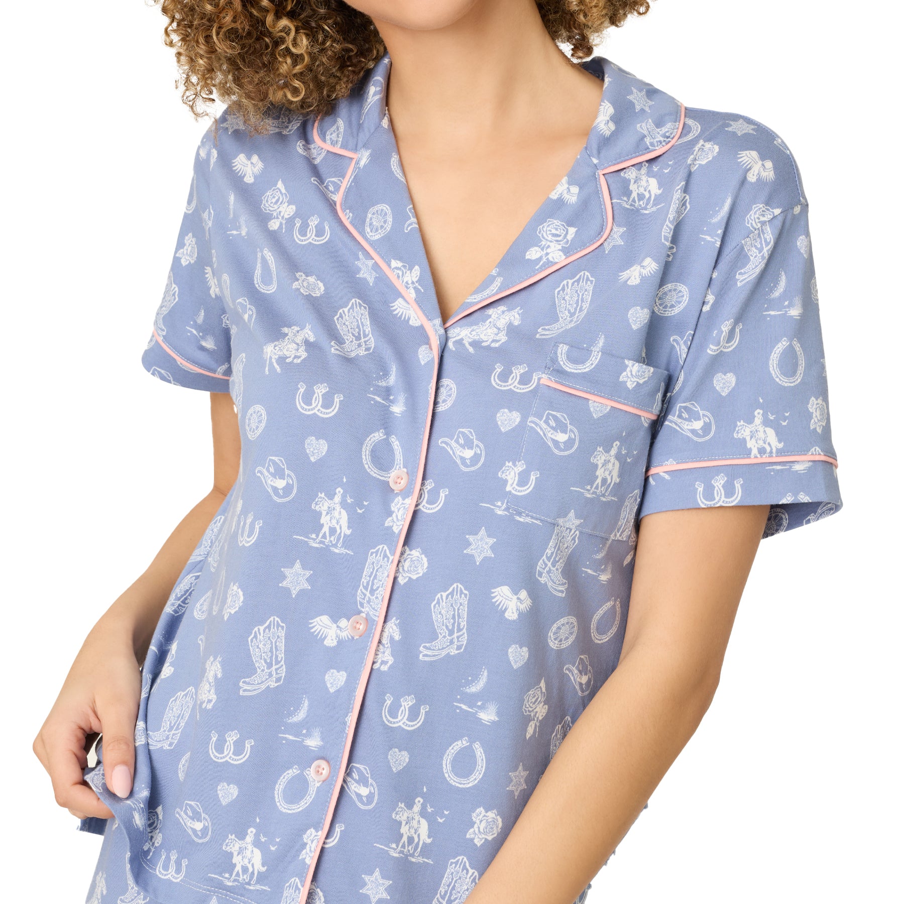 Close-up of light blue pyjama top with pink piping and western print details