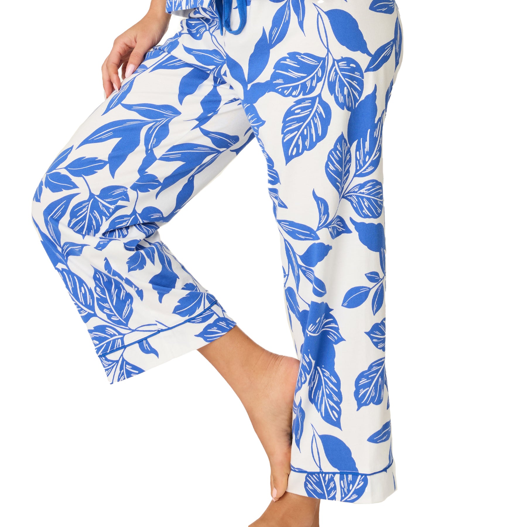 Close-up of white pyjama pants with cobalt blue floral print, soft fabric detail