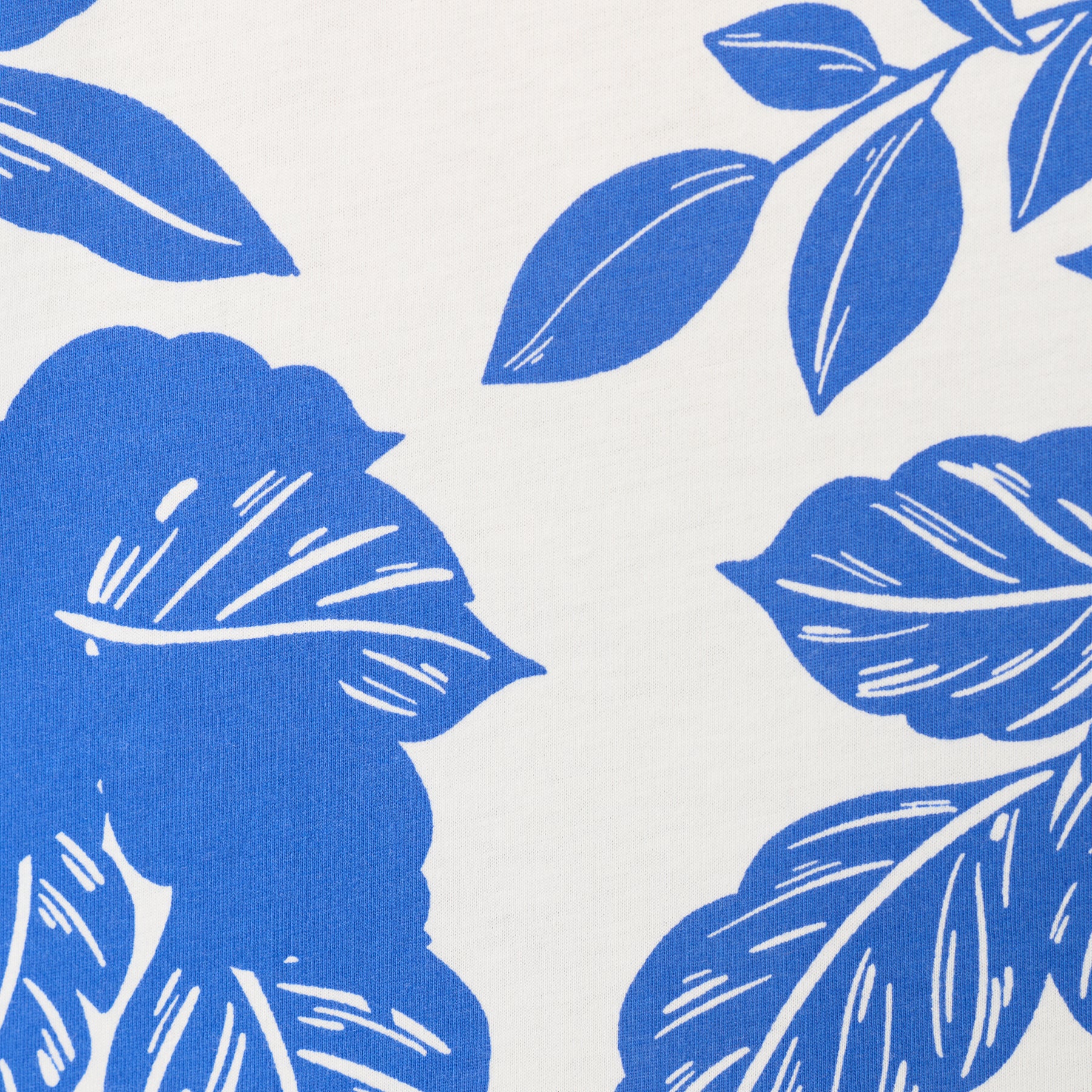 Close-up of white fabric with cobalt blue floral print, soft breathable material