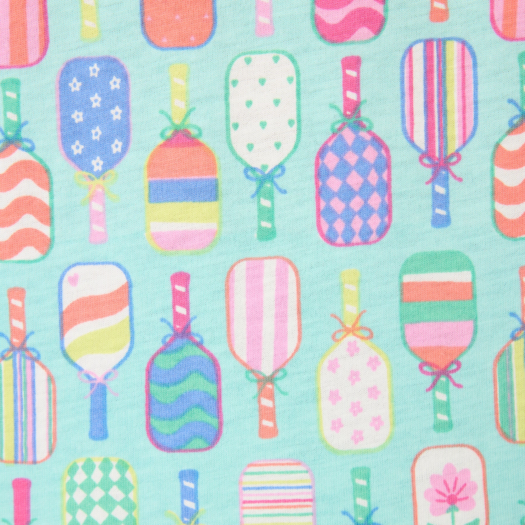 Close-up of mint green fabric with colourful pickleball paddle print, soft material detail