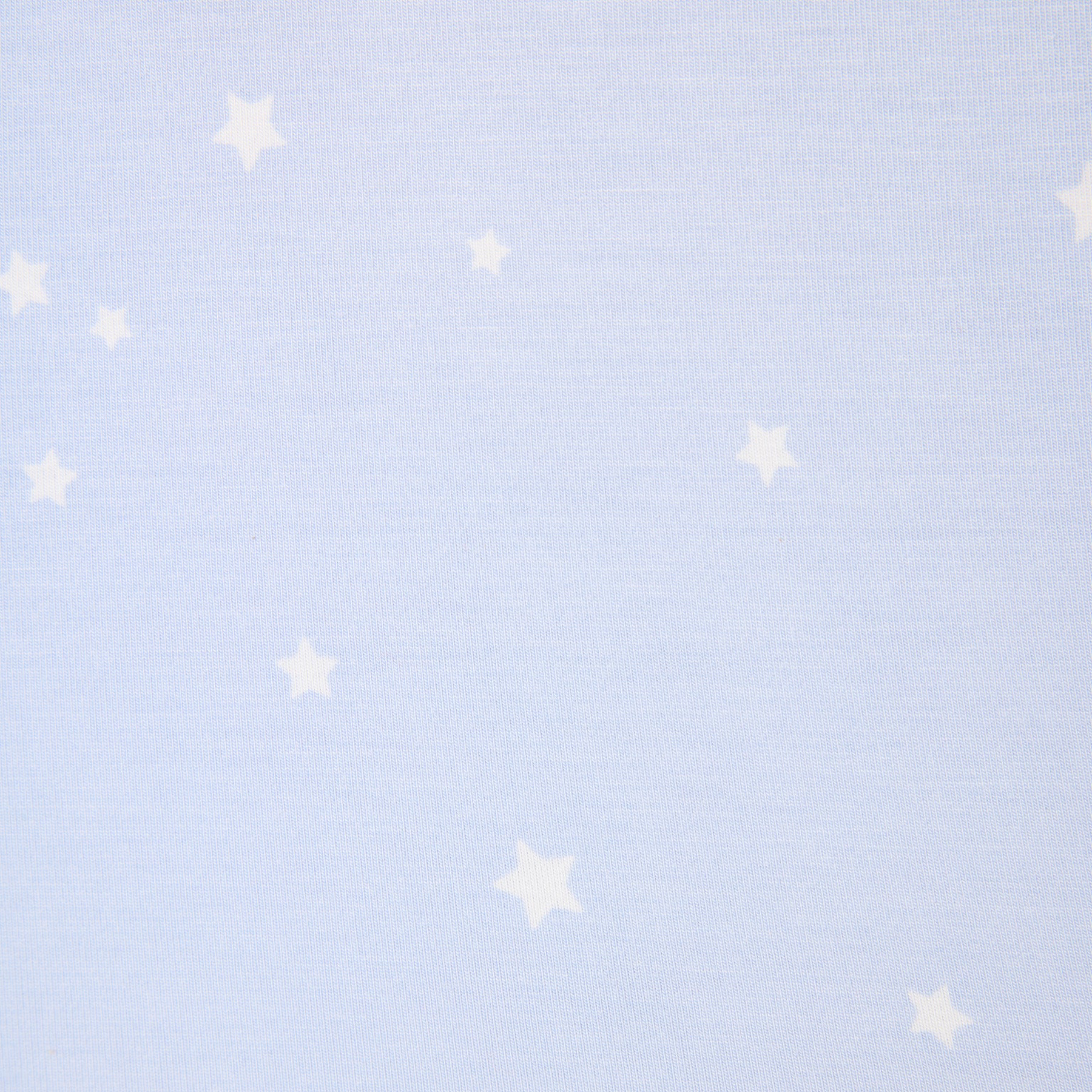 Close-up of baby blue fabric with small white star print on soft sleepwear material