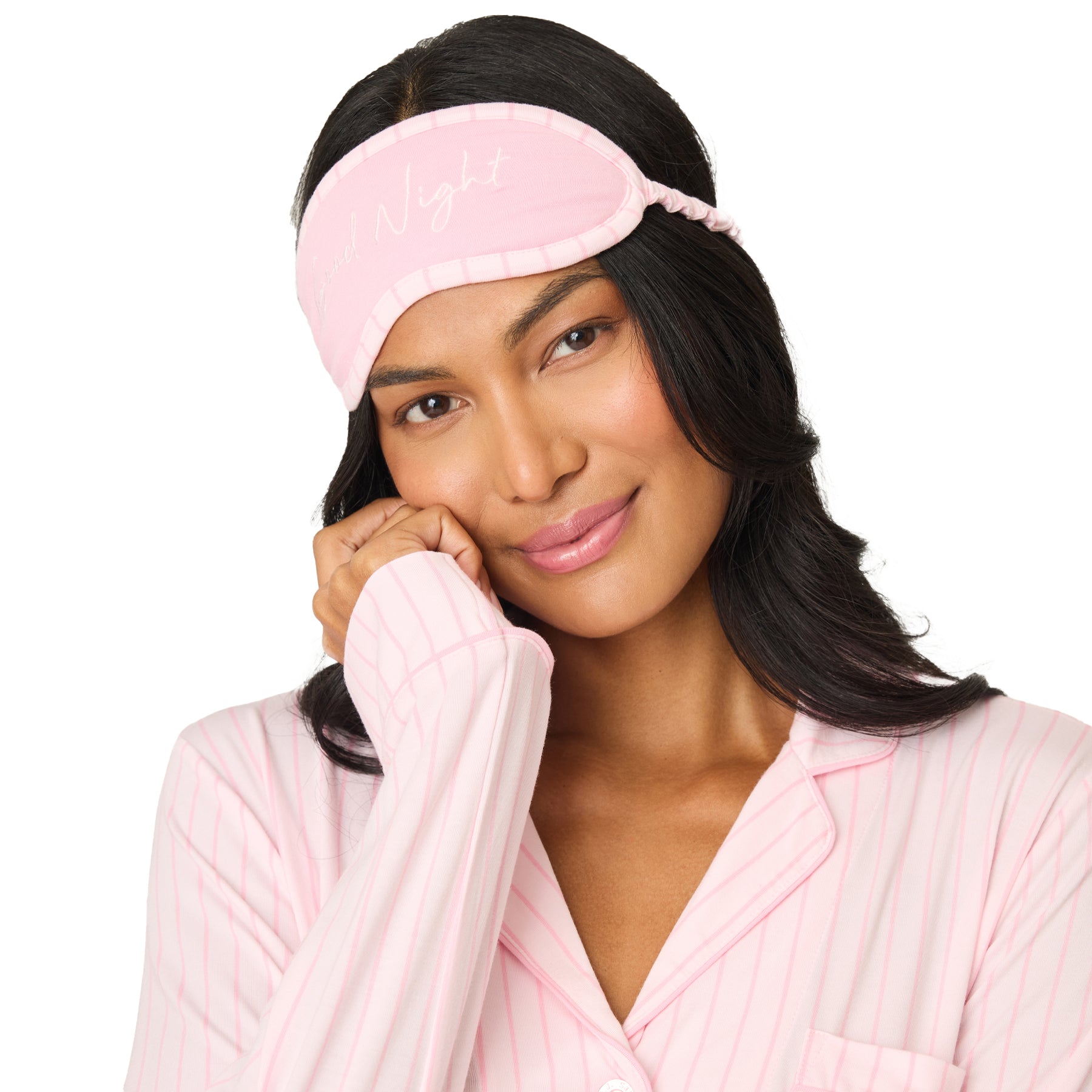 Close-up of woman wearing pink striped pyjama top and matching sleep mask, soft comfortable sleepwear