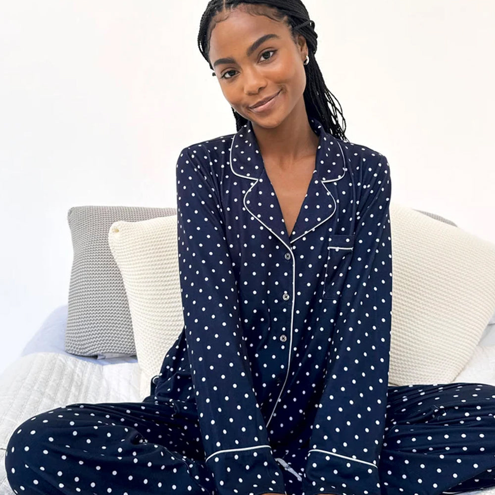 Model sitting comfortably in Splendid Pillowsoft navy polka dot pajamas, featuring a relaxed button-up top with notched collar and white piping.