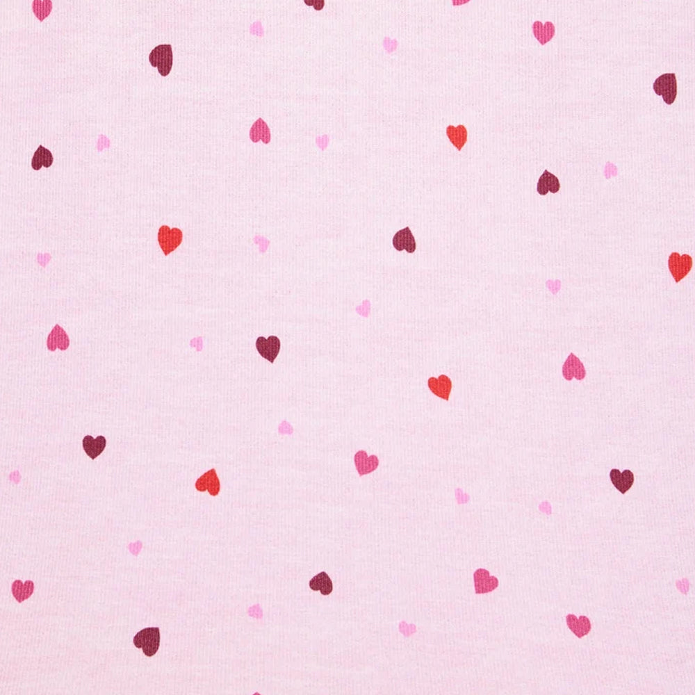 Close-up of Splendid Pillowsoft pajama fabric featuring scattered red, pink, and burgundy hearts on a soft pink background.