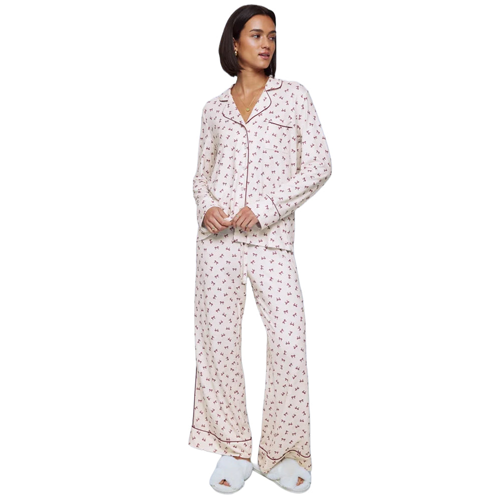 Model wearing Splendid Pillowsoft White Bow Toss PJ Set with long-sleeve button-up shirt, relaxed wide-leg pants, and burgundy piping.