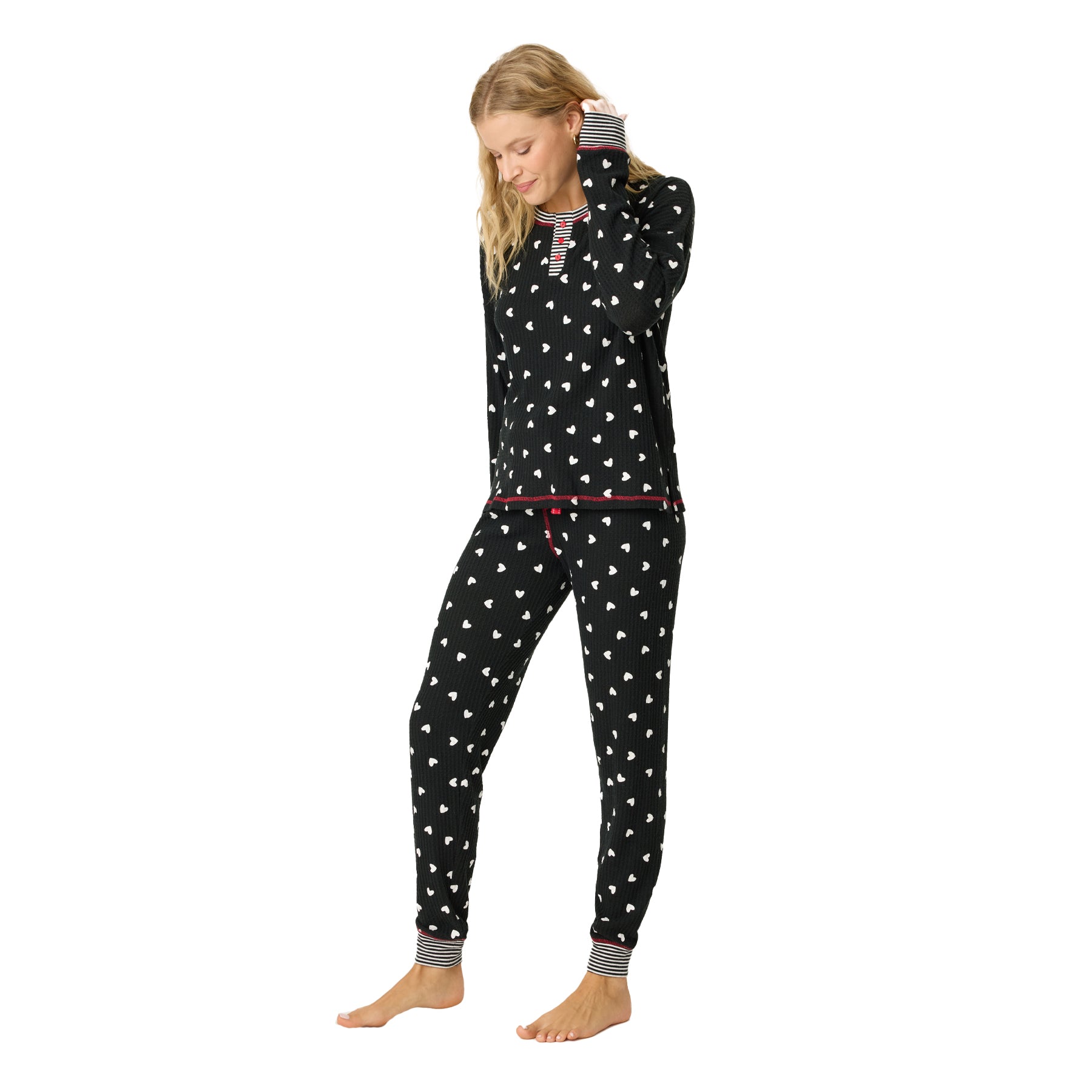 A model wearing black printed pajamas looking at the ground.