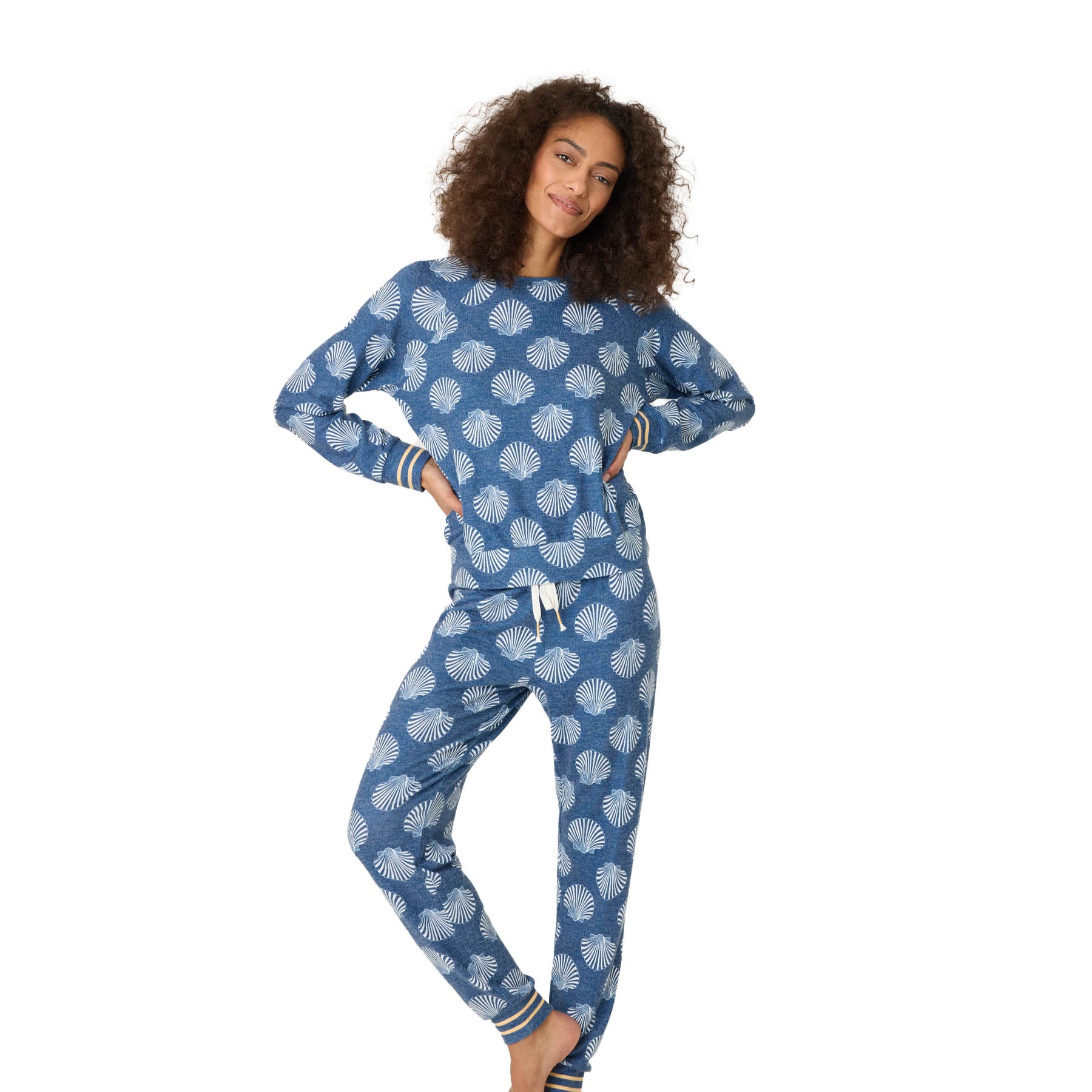 A woman modeling the full-length blue lounge set with white seashells, featuring ribbed cuffs and a relaxed fit.