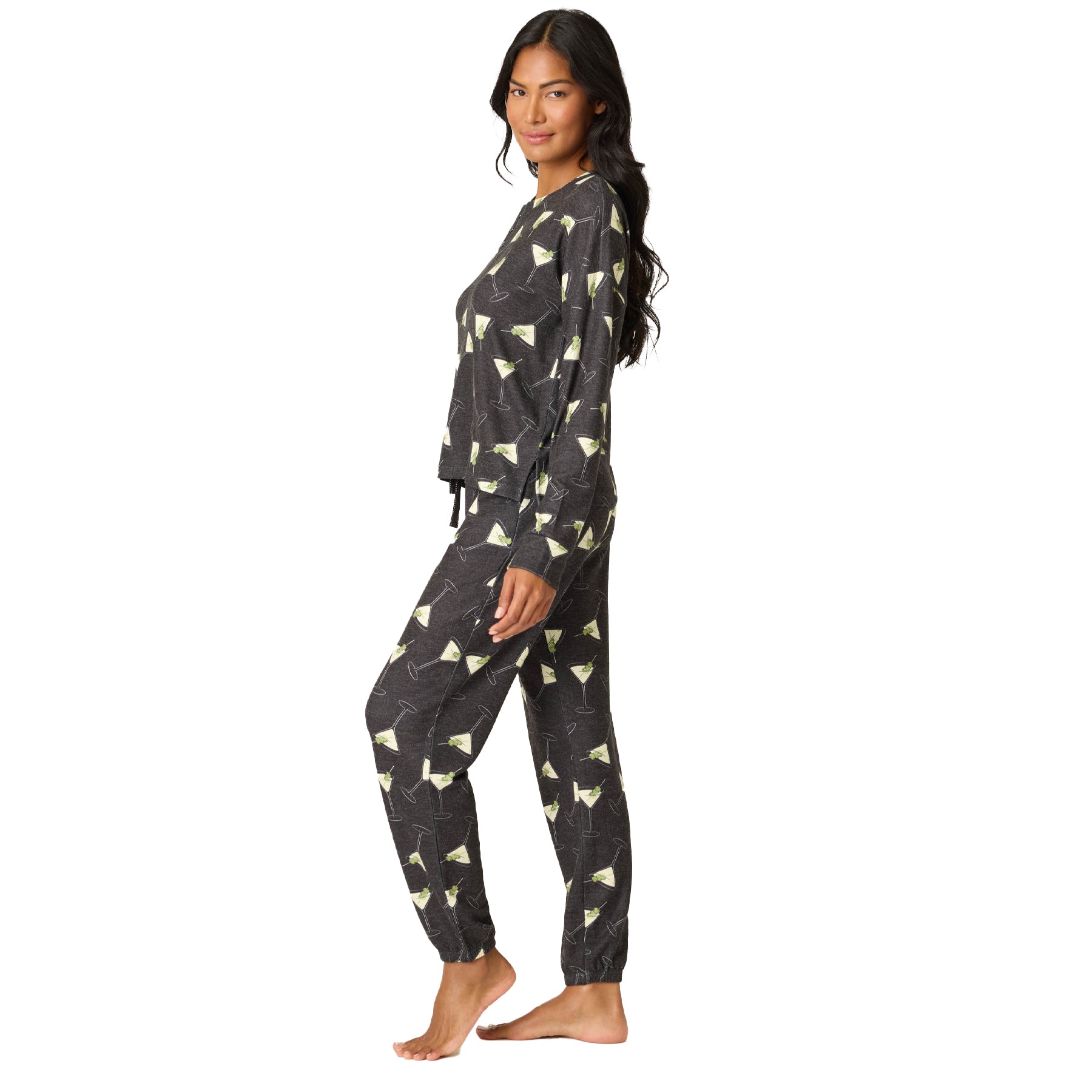 Woman wearing a dark gray pajama set with a pattern on a white background