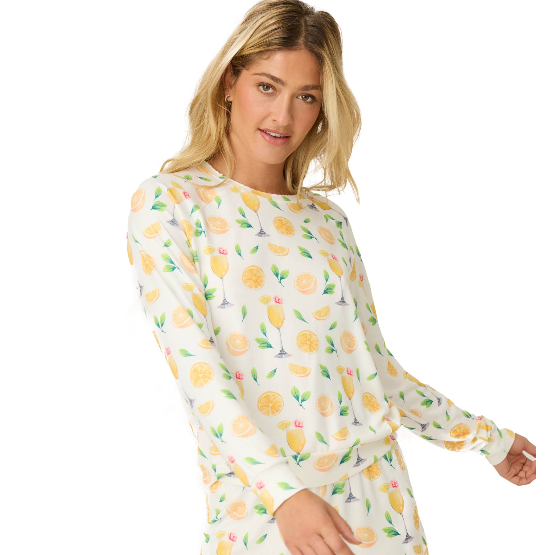 Woman in a matching ivory lounge set featuring a lemon and mimosa glass print, posing with a soft expression and relaxed posture.