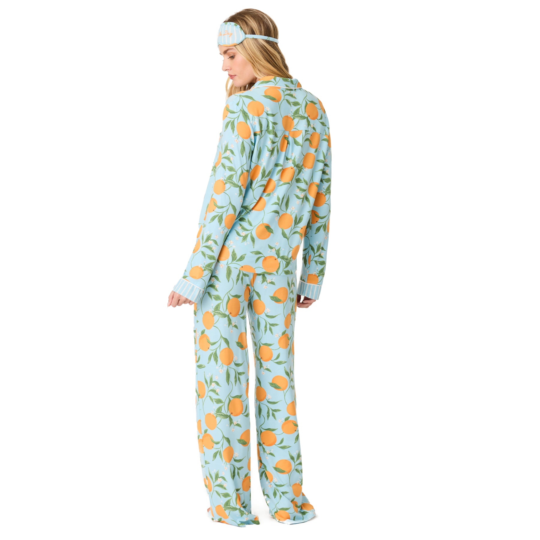 Back view of women’s citrus print pyjama set in light blue with orange fruit pattern and contrast striped cuffs