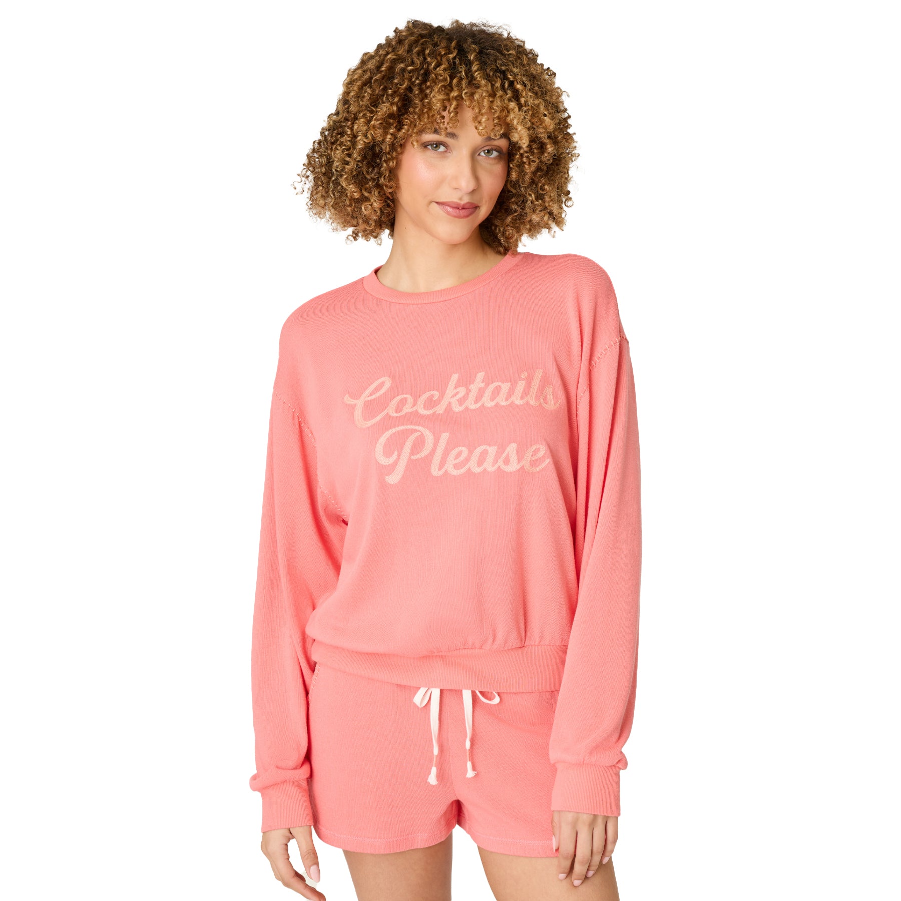 Front view of women’s coral sweatshirt with “Cocktails Please” text and matching lounge shorts