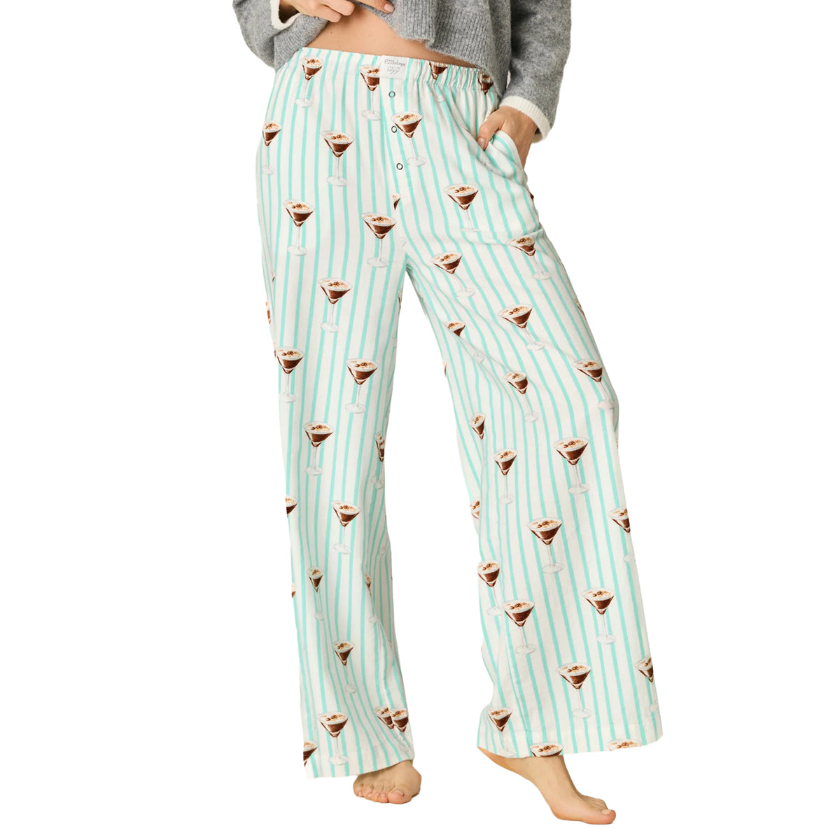 Model wearing PJ Salvage Tipsy Time pajama pants in pool blue with mint stripes and espresso martini print, front view.