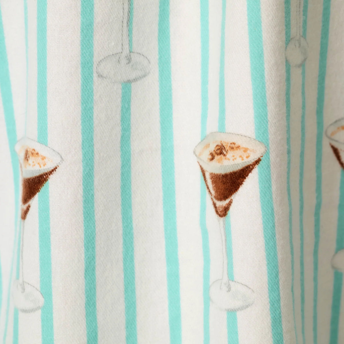 Close-up of espresso martini glass print on PJ Salvage Tipsy Time pajama pants with mint and white vertical stripes.