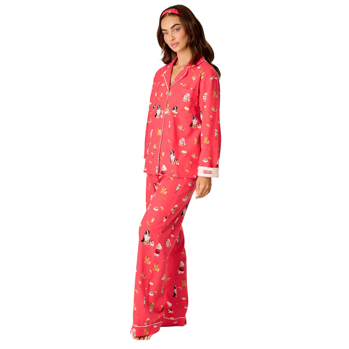 Model wearing PJ Salvage Brunch Pups coral flannel pyjama set with button-down top and relaxed pants, side view.