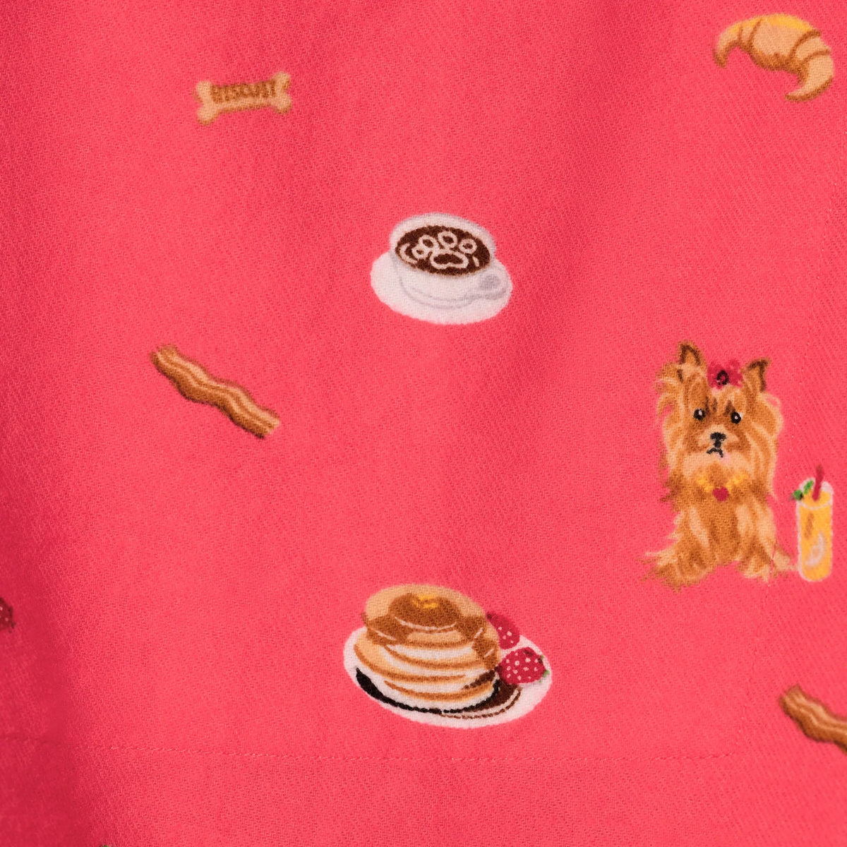 Close-up of PJ Salvage Brunch Pups coral flannel fabric featuring dogs, pancakes, coffee, croissants and breakfast-themed print.