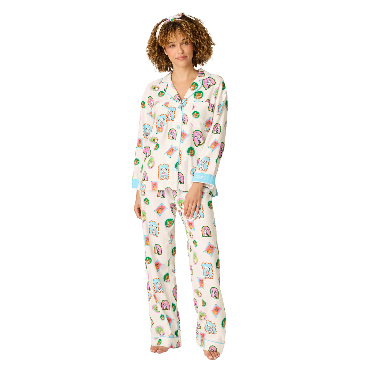Front view of cream long-sleeve pajama set featuring colorful framed dog and cat portraits, blue piping and matching wide-leg pants.