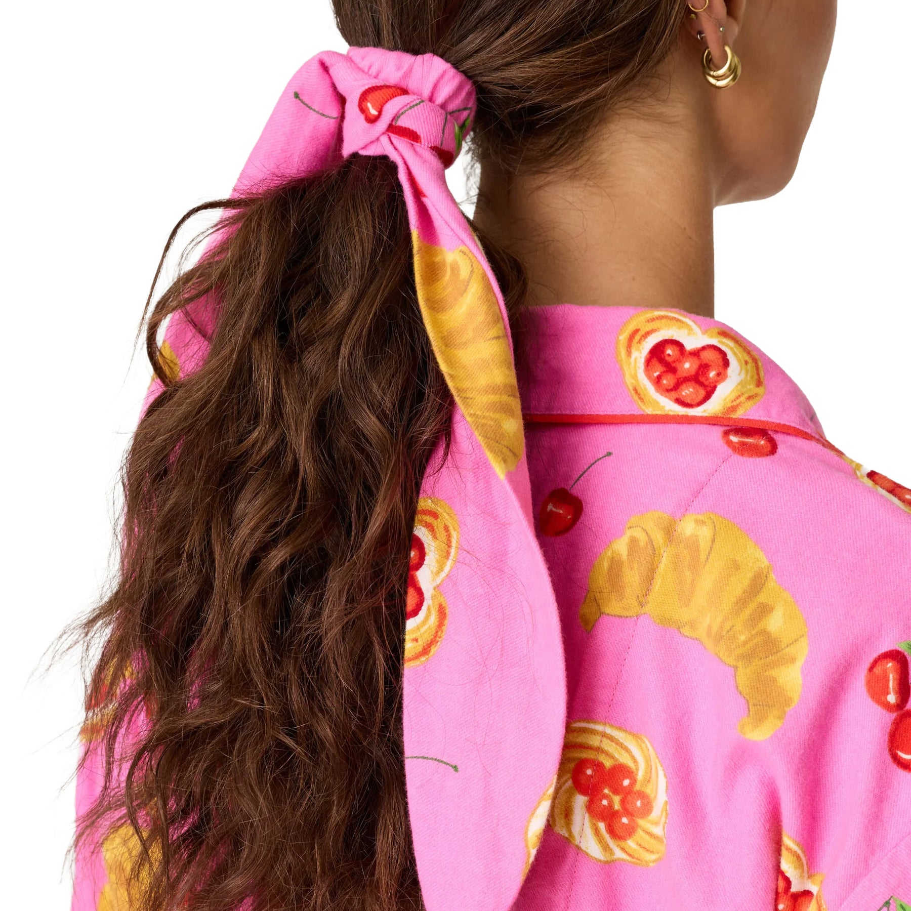 Close-up of matching pink printed hair tie featuring cherry and croissant motifs.