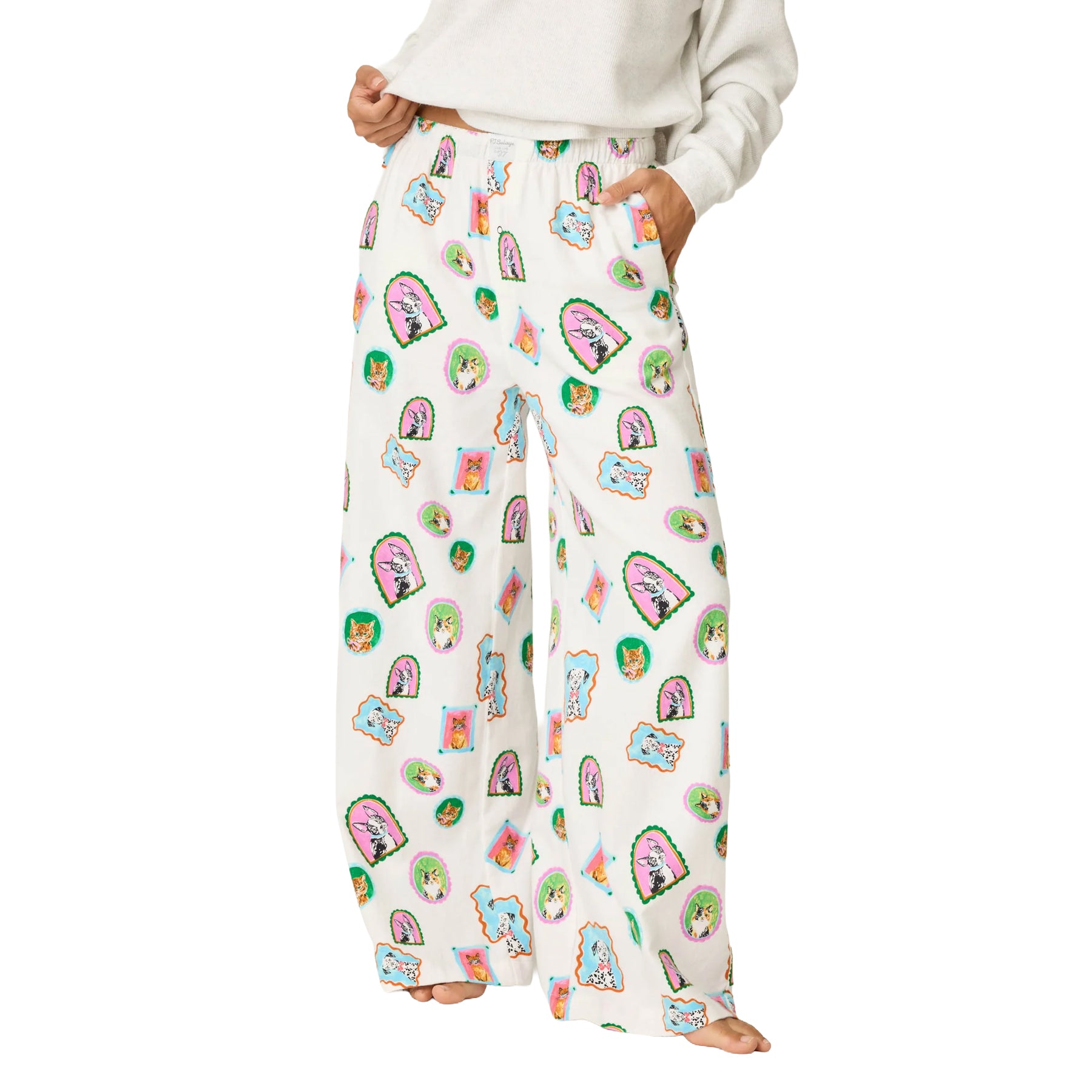 Front view of cream wide-leg pajama pants featuring a colorful framed dog and cat print, elastic waistband and side pockets.