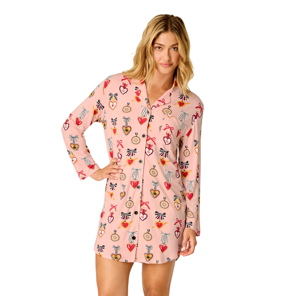 Model wearing PJ Salvage Hearts button-front sleepshirt in iced rose pink with colourful heart and bow print, front view.