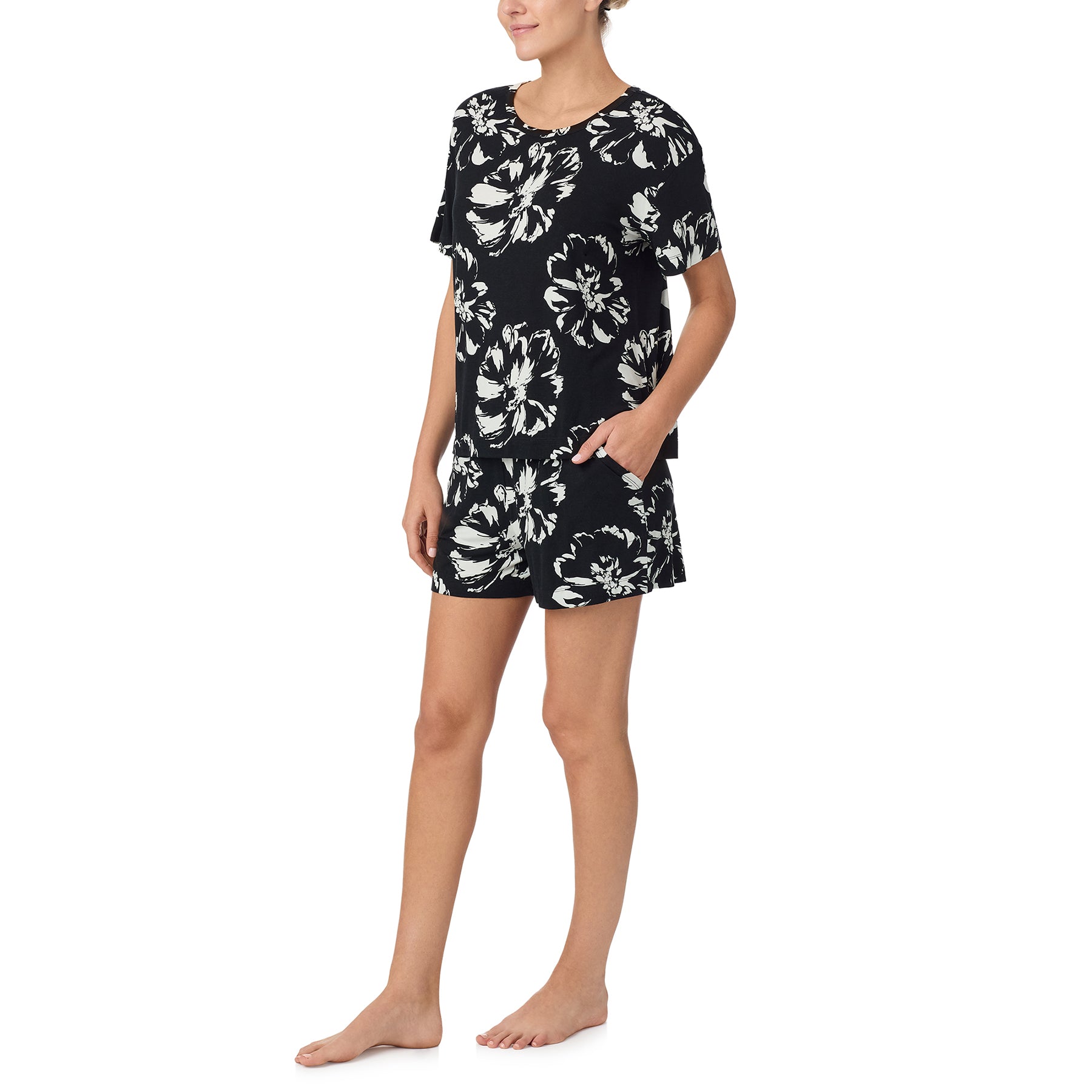 sanctuary short sleeve top and shorts set in brushstrokes print with white flowers on a black background. Side view on model.