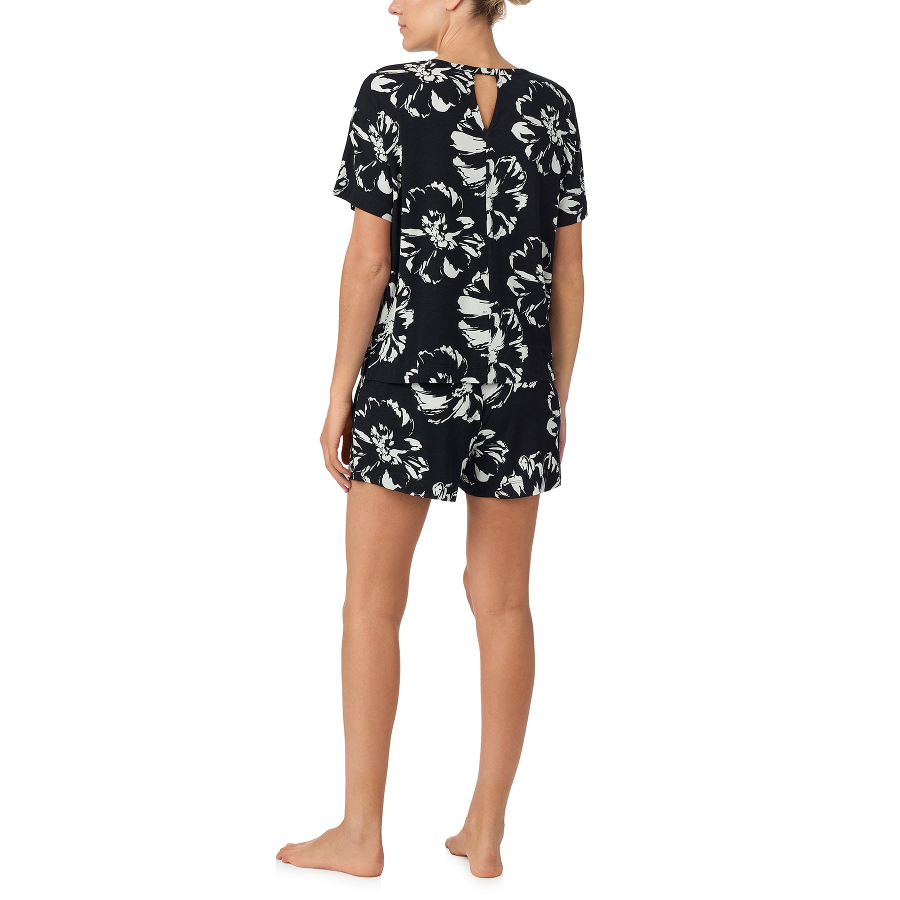 sanctuary short sleeve top and shorts set in brushstrokes print with white flowers on a black background. Rear view on model.