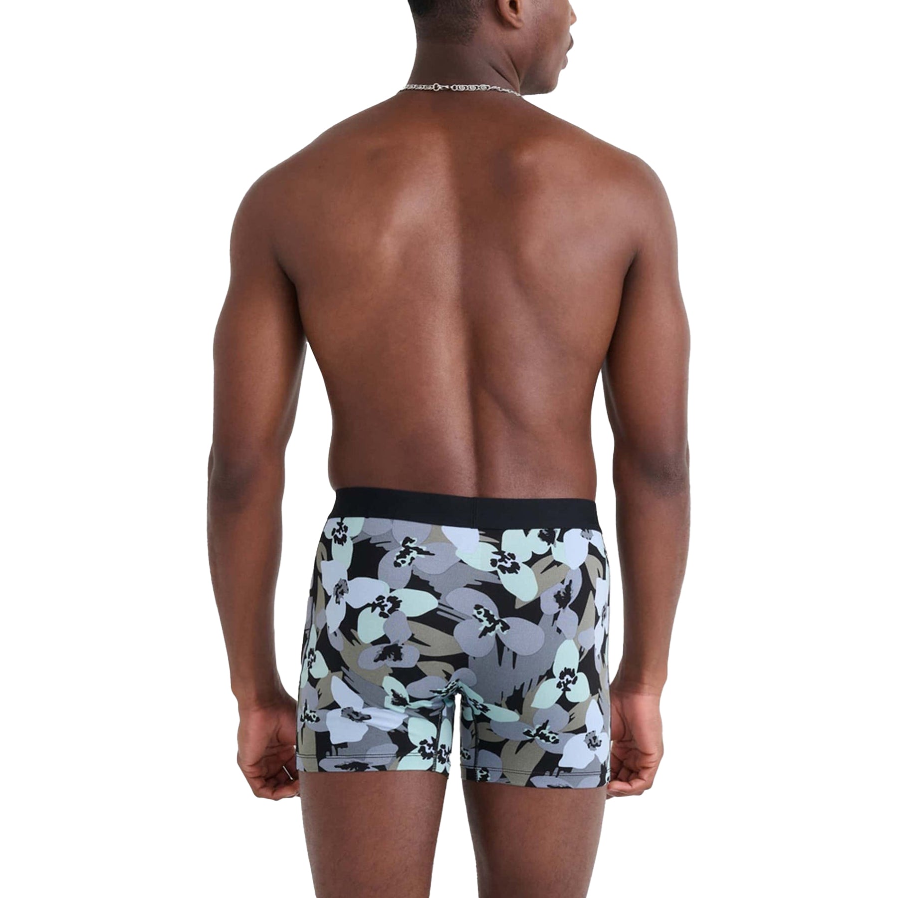 Back view of model wearing SAXX Daytripper boxer briefs in blue floral camo print - athletic fit with smooth waistband.