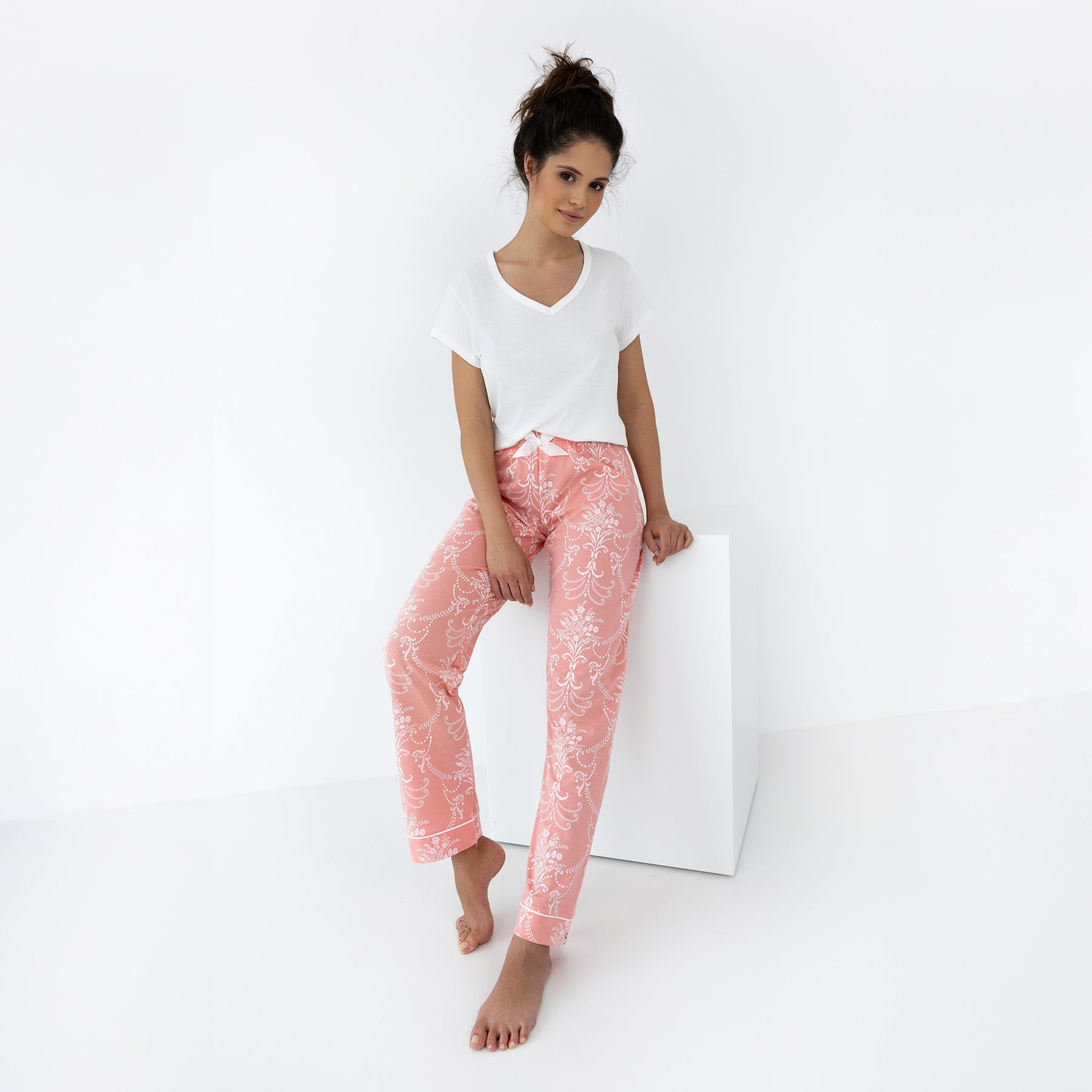 Relaxed coral floral print pants with cuffed hem and white V-neck T-shirt, styled for sleepwear or lounging