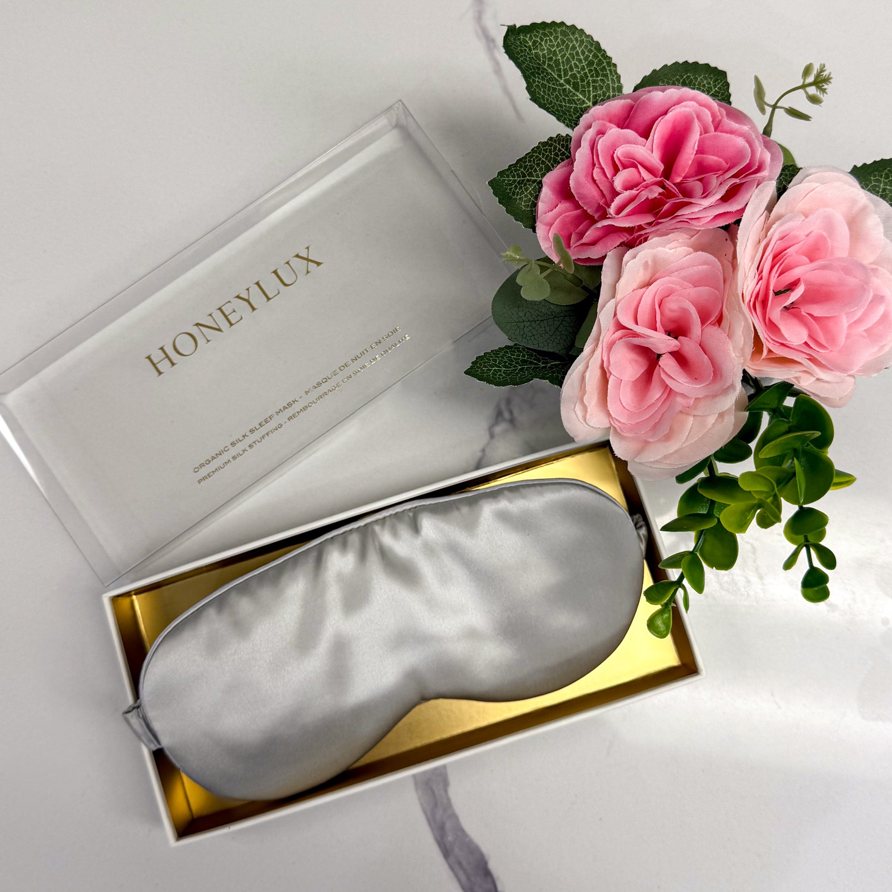 Honeylux light grey silk sleep mask in gift box with pink flowers, display view.