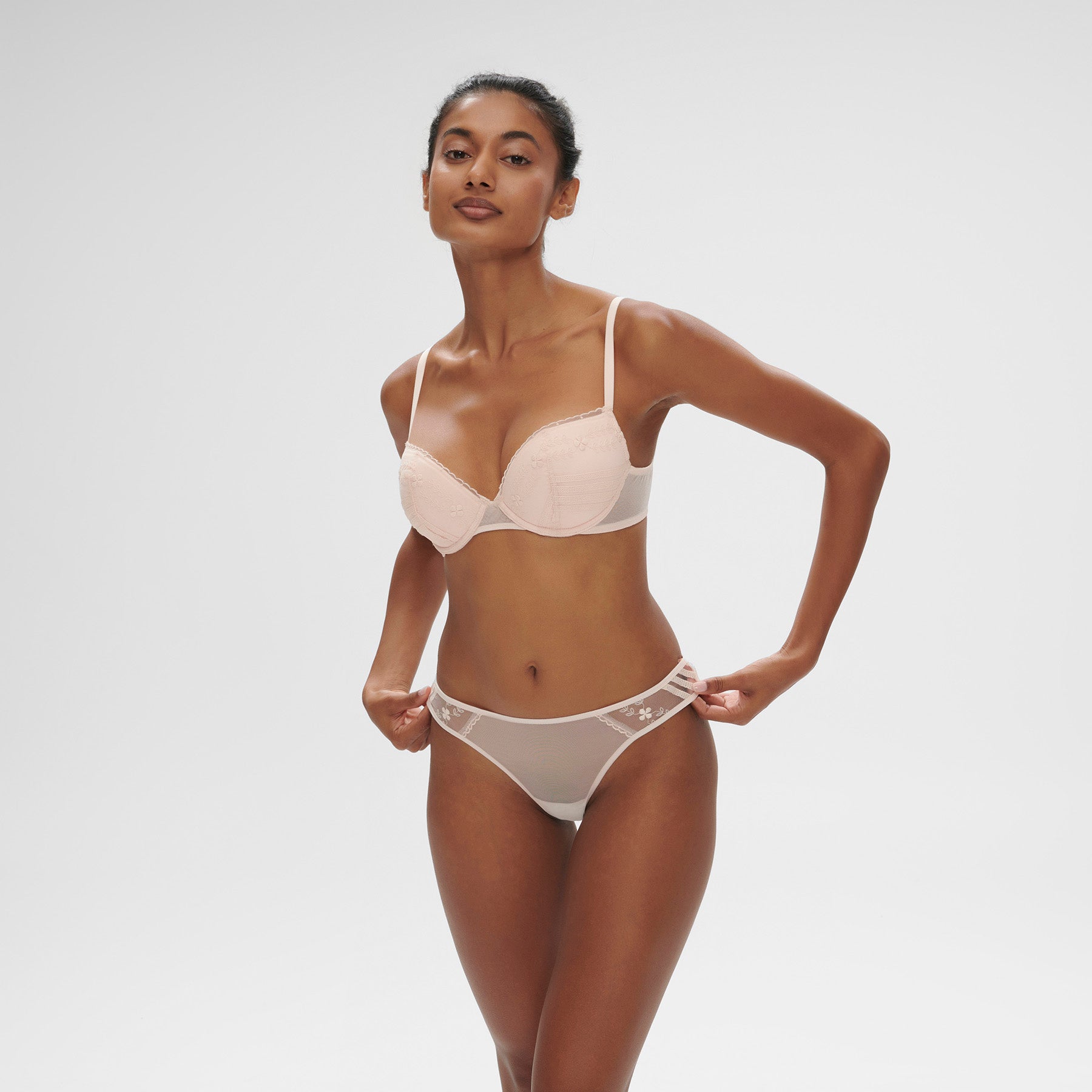 Push up bra in petal powder baby pink with embroidered details on tulle. On model, front view.