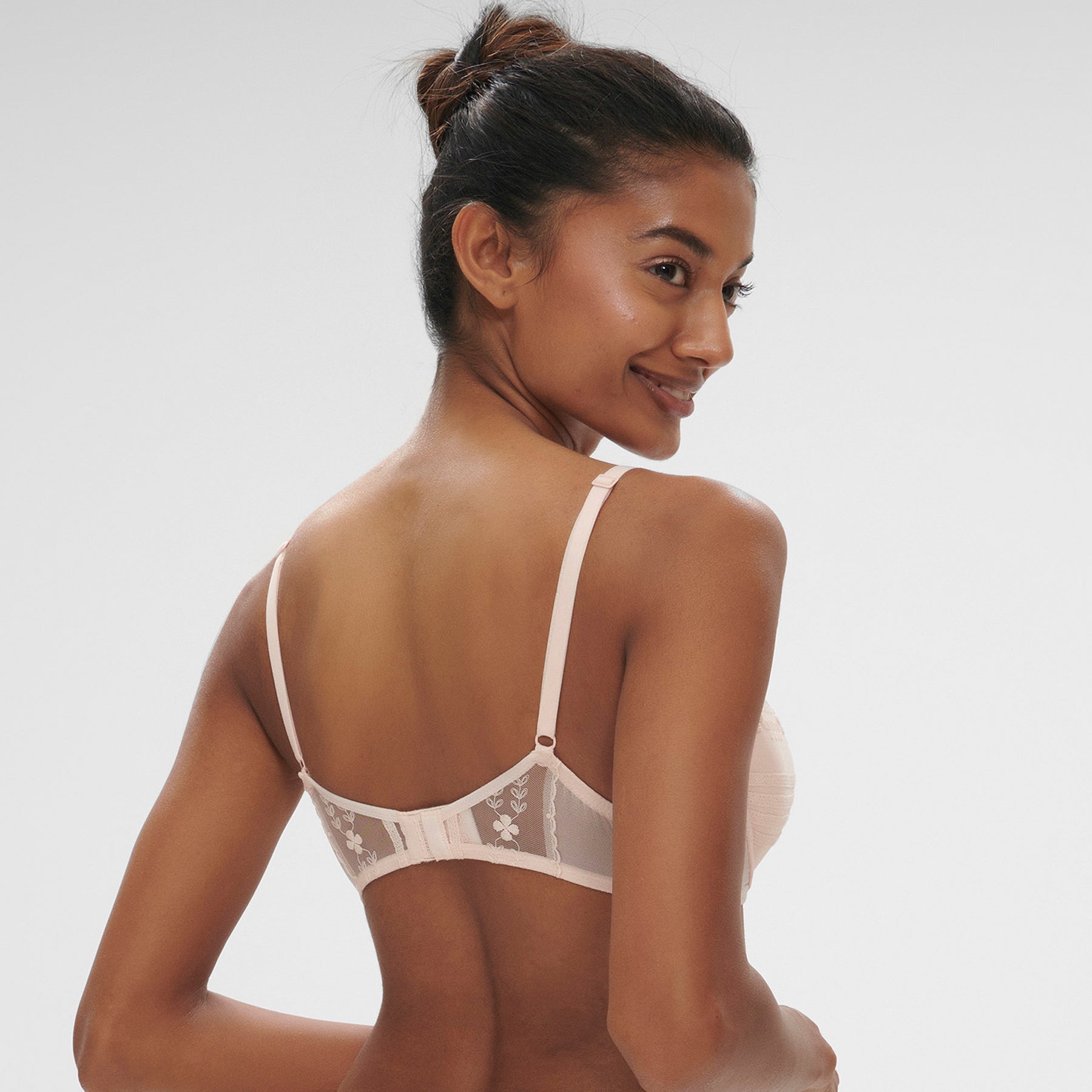 Push up bra in petal powder baby pink with embroidered details on tulle. On model, rear view.