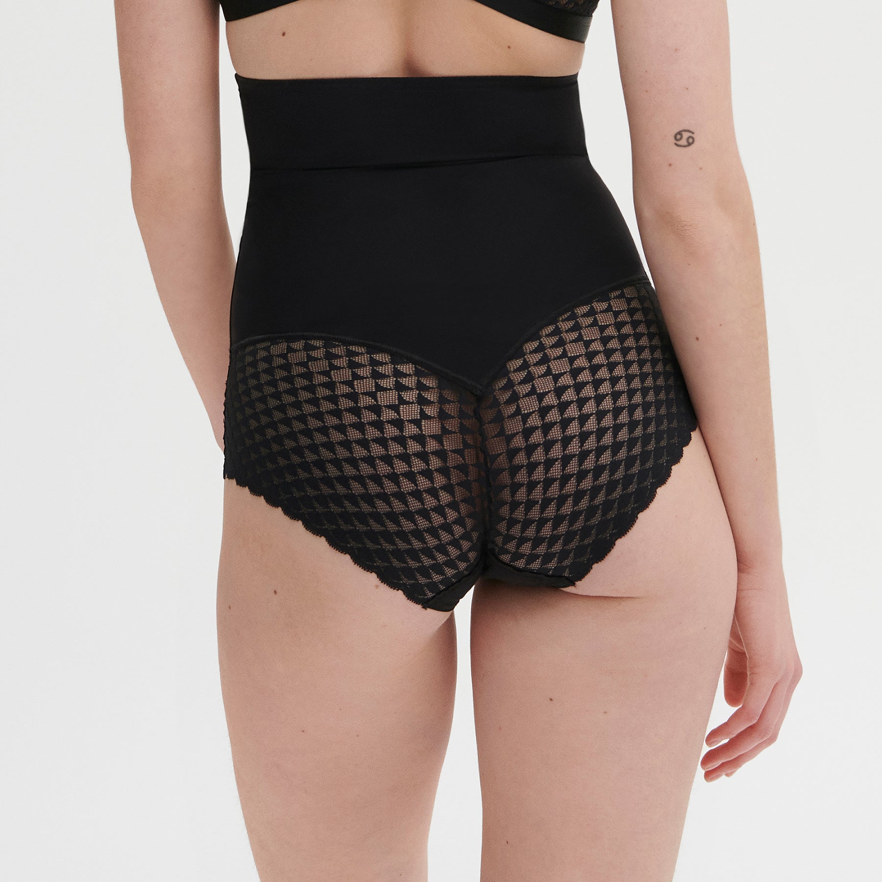 High waist control brief in black with lace detail. Rear view, on model.