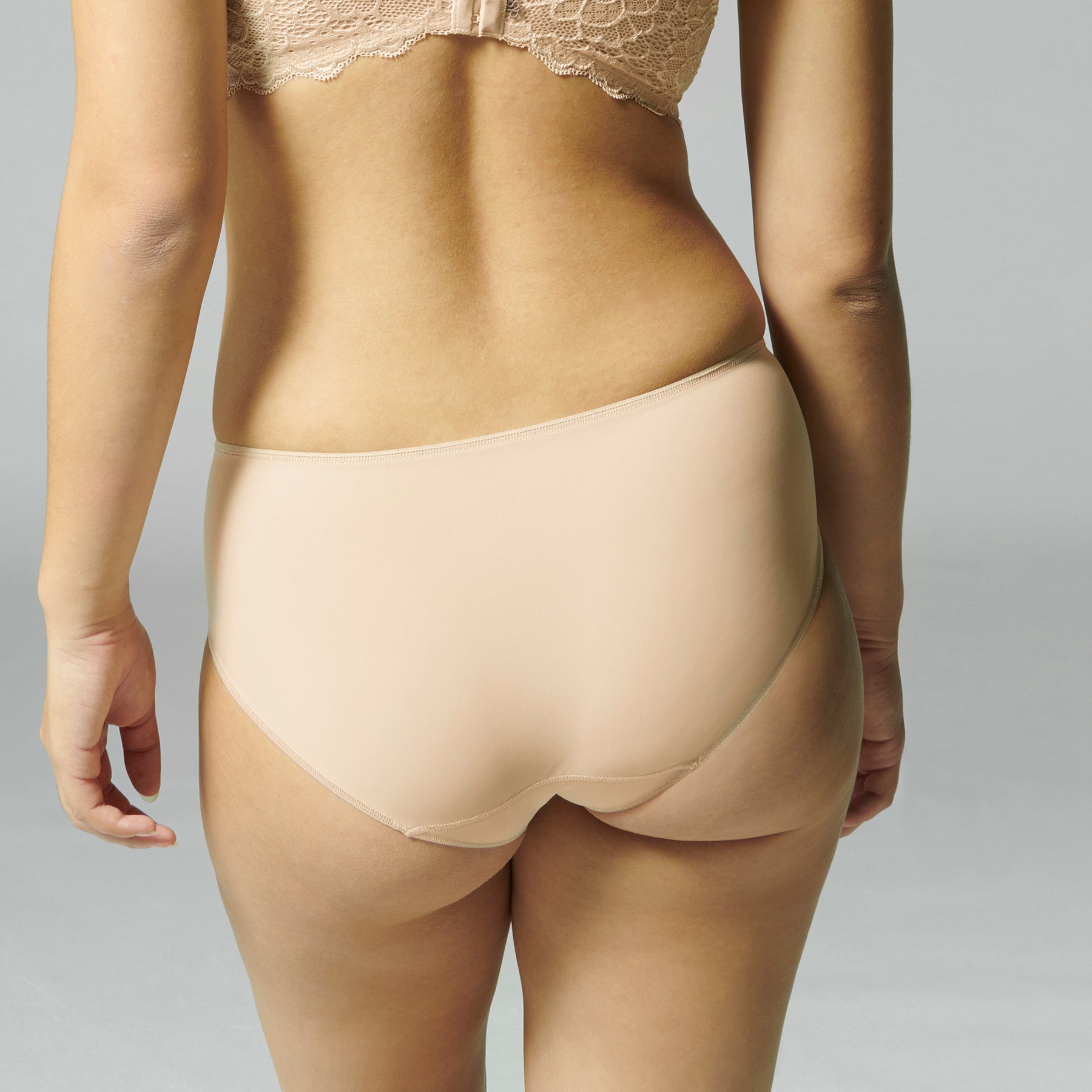 Simone Perele Caresse Control Brief in nude peau rose. Rear view on model.