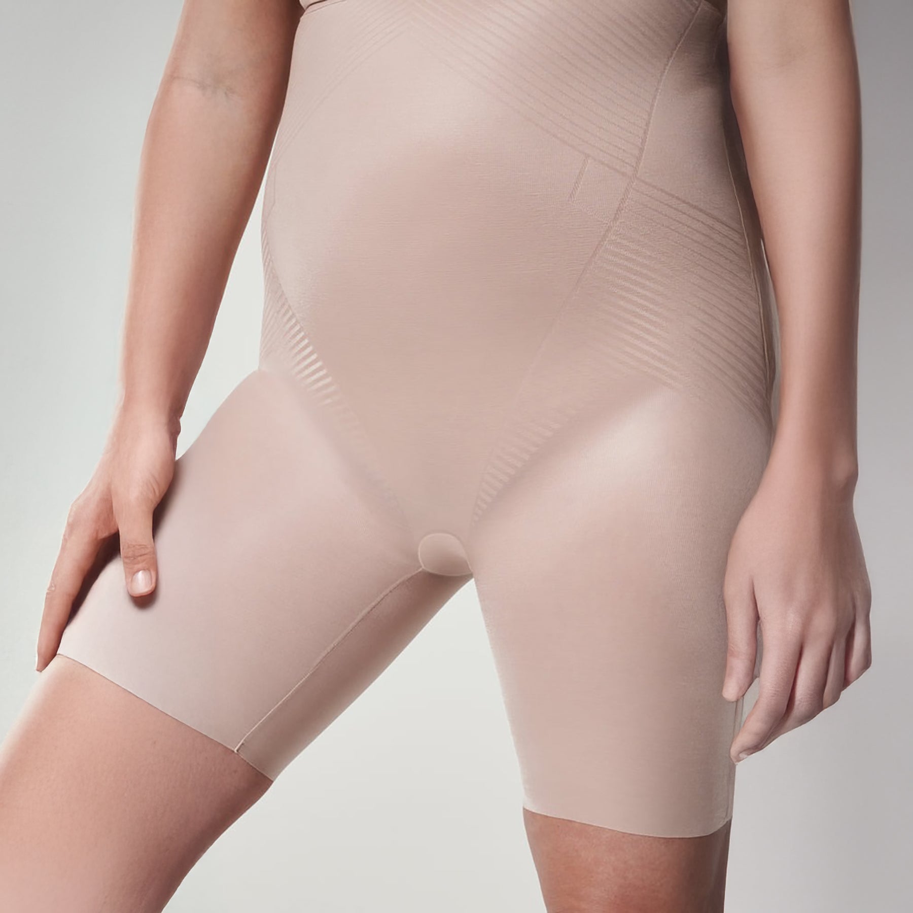 Close-up of SPANX Champagne Beige control shorts showing sculpting compression zones for tummy, hips, and thighs.