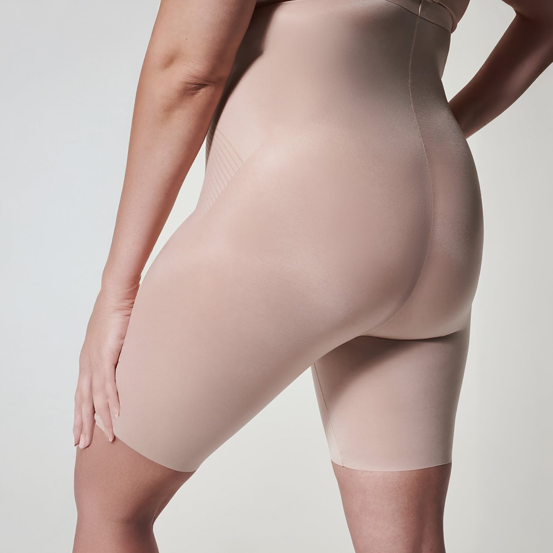 Back view of SPANX Champagne Beige high-waist mid-thigh shorts showing seamless shaping and curve-enhancing fit.