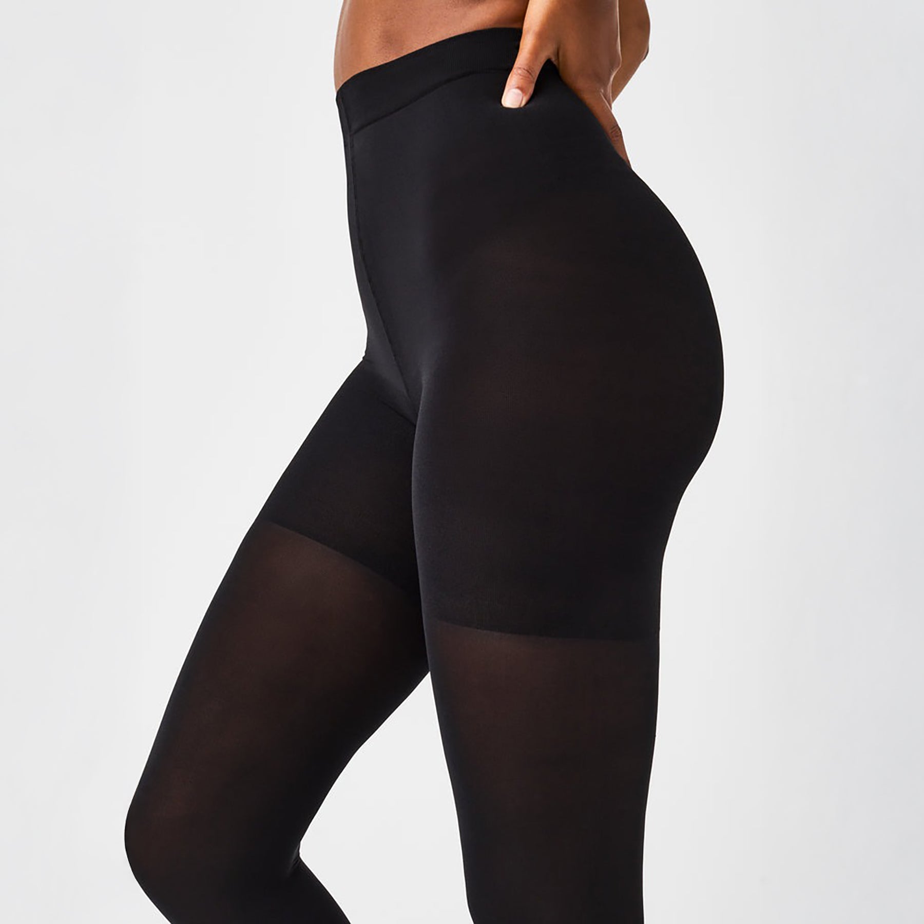 Close-up side view of SPANX Tight-End Control Tights in black showing firm compression and sleek opaque finish.